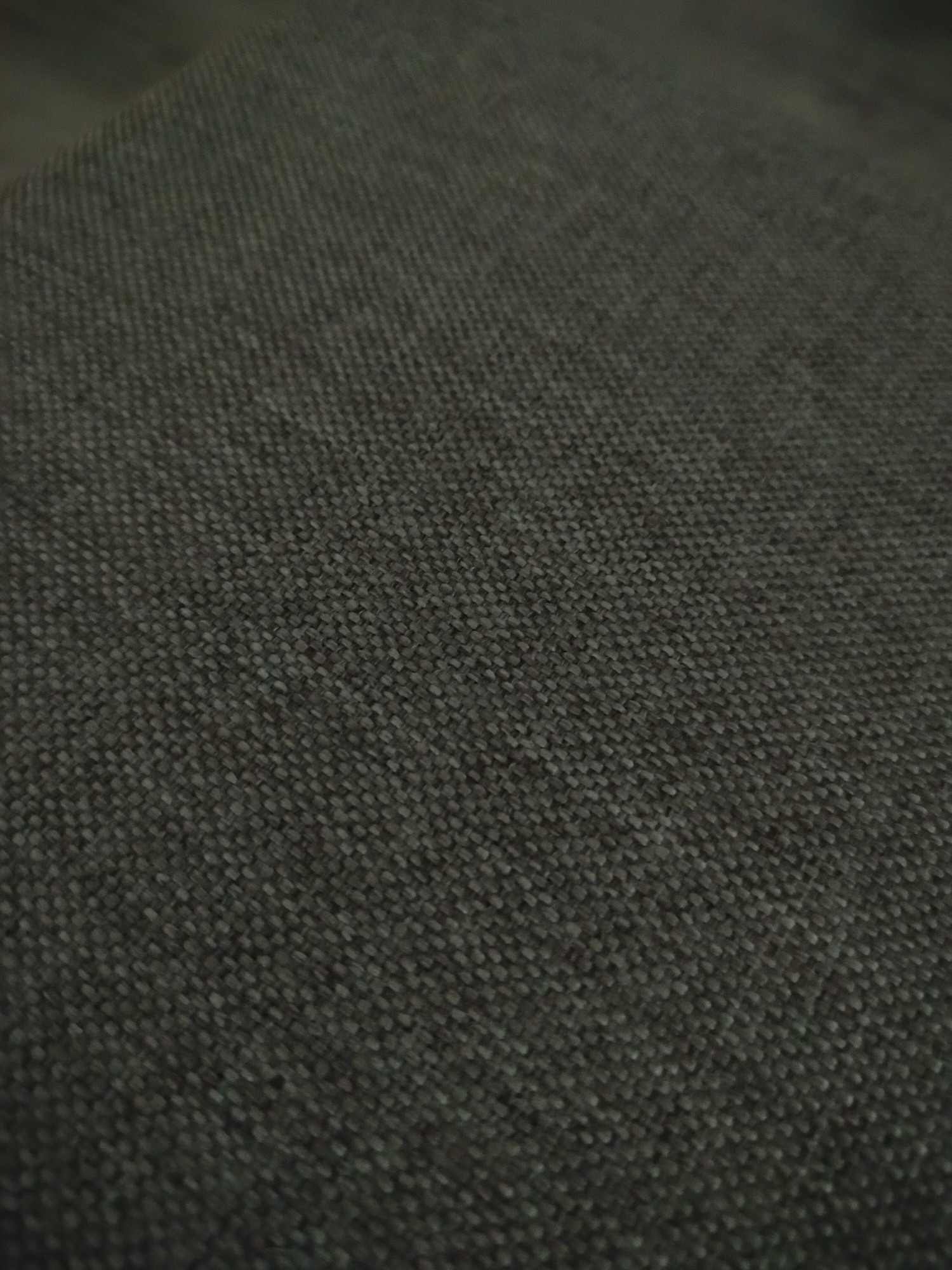 The image shows a close-up view of a textured, dark gray fabric. The weave is tight and regular, creating a pattern of small, interconnected squares. The fabric appears to be part of a larger object, possibly furniture. There is no discernible information in the image to connect it to the city of Yerevan, Armenia.