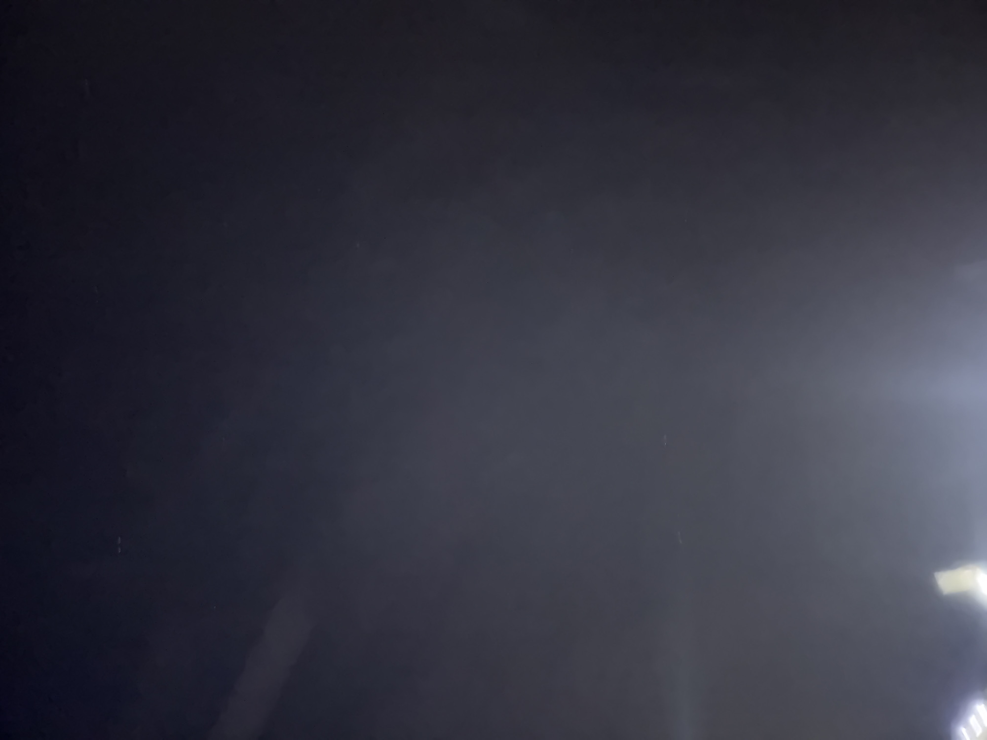 The image is a dark, blurry photograph, possibly taken at night. It appears to be an outdoor scene with some faint lights visible at the bottom, suggesting artificial illumination. The overall lack of detail makes it difficult to identify specific objects or people. The image does not provide any identifiable landmarks or contextual information that would allow for its location to be determined within Boreti, Montenegro or any other specific location.