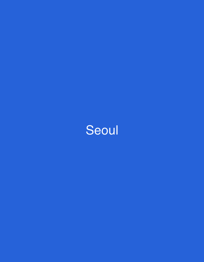 The image displays a solid, uniform royal blue background. Centered horizontally and vertically within the frame is the single word "Seoul" rendered in clean, sans-serif white capital and lowercase letters. There are no other visual elements present, such as people, objects, actions, or environmental details. The scene depicts only text on a colored background. The image provides no visual information to indicate a location within the city of Casablanca, Morocco; the text "Seoul" refers to the capital of South Korea.
