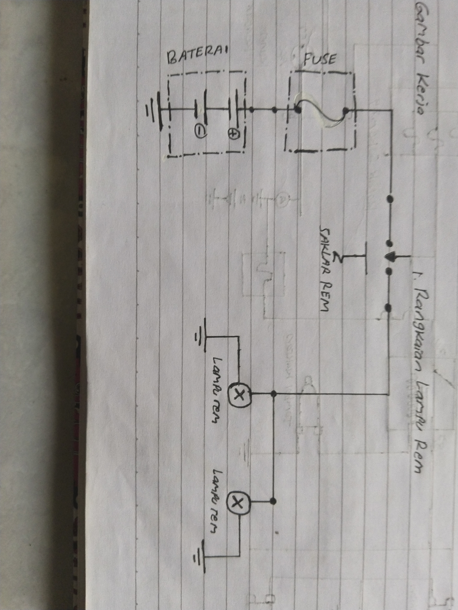 The image displays a hand-drawn electrical schematic diagram on lined paper. The diagram features several components including a battery labeled "BATERAI", a fuse labeled "FUSE", a switch labeled "SAKLAR REM", and two lamps labeled "LAMPU REM". The schematic illustrates a circuit with the battery connected through the fuse and switch to the two lamps, which are then grounded. The diagram is oriented vertically, with text labels written in Indonesian. A title at the top right of the image reads "Gambar Kerja", meaning "Working Drawing". The overall environment appears to be indoors, likely a personal workspace, with no visible elements of the city of Kebondalem, Indonesia.