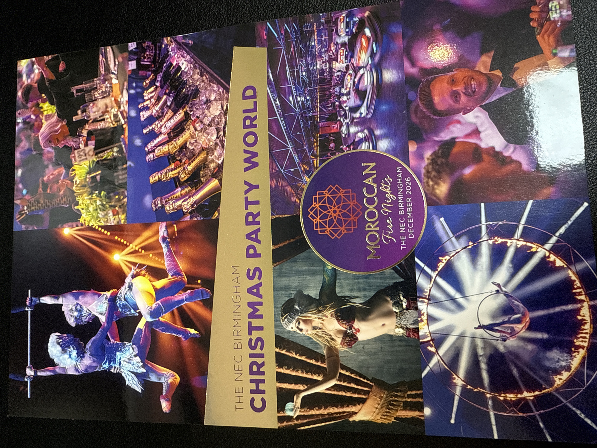 This media file is a vibrant, collage-style promotional image for a large event. It is composed of several smaller photographs depicting various aspects of a "Christmas Party World" event with a "Moroccan Fire Nights" theme, hosted at The NEC Birmingham.
The image showcases a mix of activities and scenes. Several sections feature party-goers, with smiling individuals enjoying drinks, including bottles of Moët and Piper-Heidsieck champagne chilling in ice buckets at a bar area. The atmosphere appears festive and lively.
Prominently featured are professional performers. One section captures two acrobats in colorful, ornate costumes, performing an aerial routine with a trapeze bar against a backdrop of warm, glowing lights. Another segment shows a female performer in an exotic, belly-dancer style costume, manipulating a glowing orb. A dramatic scene displays an aerialist performing inside a flaming hoop or ring, illuminated by stark white spotlights.
The overall impression is one of an exciting, high-energy event combining a lavish party environment with spectacular live entertainment. The lighting across the different scenes suggests an evening or night-time event. The color palette of the image is rich, with deep purples, blues, golds, and reds, contributing to an exotic and celebratory mood.
Visible text includes:
* "THE NEC BIRMINGHAM" (appears twice)
* "CHRISTMAS PARTY WORLD"
* "MOROCCAN Fire Night's"
* "DECEMBER 2026"
* "MOET" (on champagne bottles)