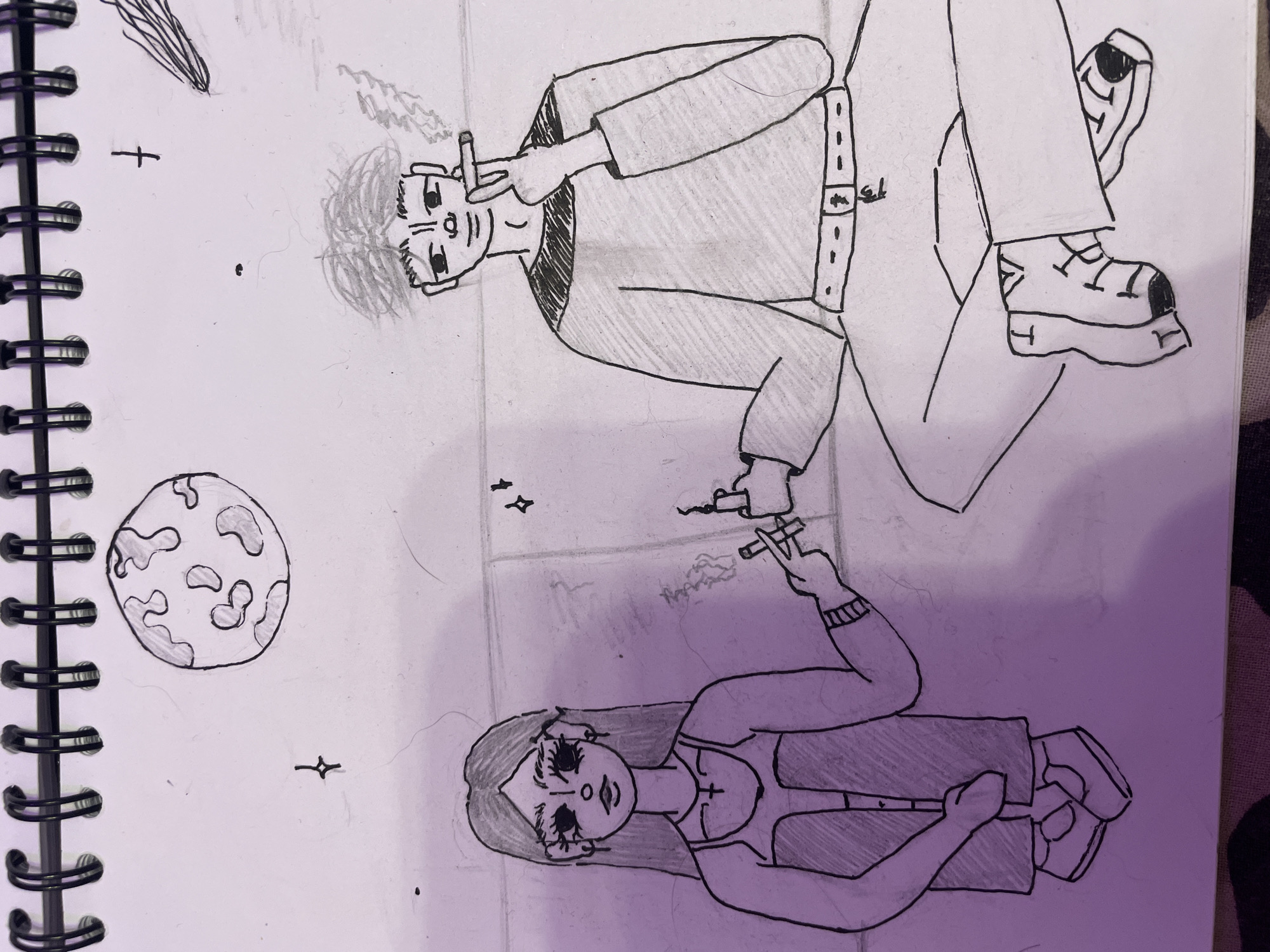 The image is a drawing on a notebook page. It depicts two figures in a surreal, possibly outer space or dreamlike setting.
The upper figure is a female, drawn in a stylized, somewhat cartoonish manner. She has long, dark hair, large, wide eyes with heavy eyeliner, and a small mouth. She is wearing a light-colored top with a dark overlay and what appear to be high-waisted pants. Her arms are bent, and she is holding what looks like a cigarette or a similar object with smoke emanating from it. Her legs are drawn bent, and her feet are in sneakers.
The lower figure is a male, also drawn in a stylized way. He has short, dark hair, dark eyes, and a neutral expression. He is wearing a collared shirt with a patterned design on the upper part and solid pants with a belt. He is also holding a cigarette or similar object with smoke. His legs are crossed, and he is wearing sneakers.
Between and around the figures, there are several celestial elements: a planet with irregular patches, a star-like symbol, and another smaller, more abstract shape that could be another celestial body or a shooting star. The background is blank, indicating an abstract or undefined environment.
The notebook page itself has a spiral binding on the right side. The drawing is done primarily with black ink and some light pencil shading.
There is no indication of a specific location in Borisova Griva, Russia, within the image itself. The scene is entirely fantastical.