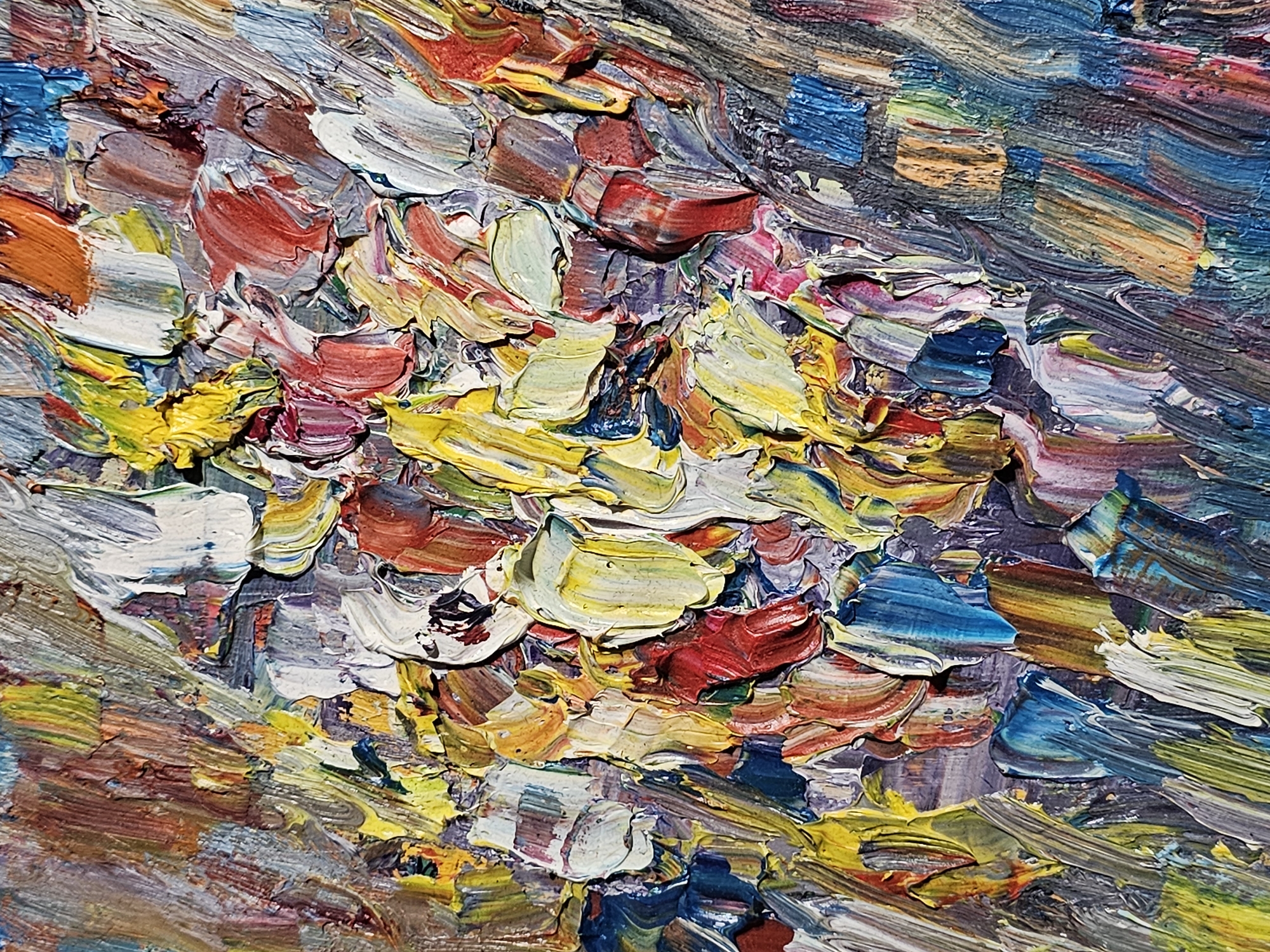 The image is a close-up of a heavily textured oil painting. Dominant colors include yellow, white, red, blue, and brown. The brushstrokes are thick and layered, creating a three-dimensional effect. The painting does not appear to depict any recognizable subjects or figures, leaning towards abstract expressionism. No information suggests that the image is related to Plovdiv, Bulgaria.