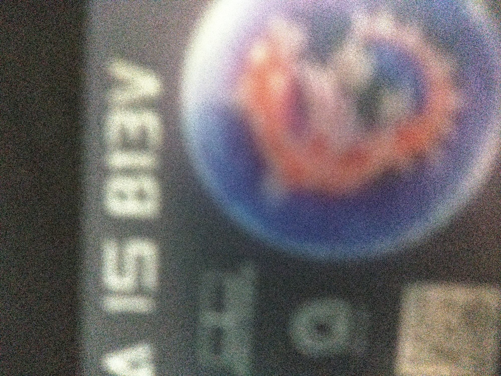 The image contains a blurred view of a bus stop sign, with the text "А413 В13В" vertically written on the left side. To the right, partially visible, is a round sign with a logo, possibly related to public transportation. The location appears to be Sofia, Bulgaria, based on the Cyrillic alphabet used in the text.