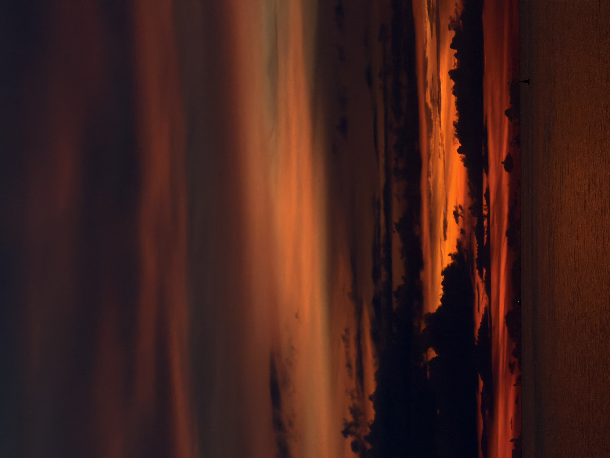 The image depicts a dramatic sunset over the ocean, likely near Ko Pha Ngan, Thailand. The sky is ablaze with vibrant hues of orange, red, and dark purple, with clouds streaking horizontally. The ocean reflects the fiery colors of the sky, creating a warm, intense atmosphere. In the distance, a small, dark silhouette of what appears to be a buoy or marker can be seen in the water. The scene is tranquil and evokes a sense of natural beauty and the power of the elements.