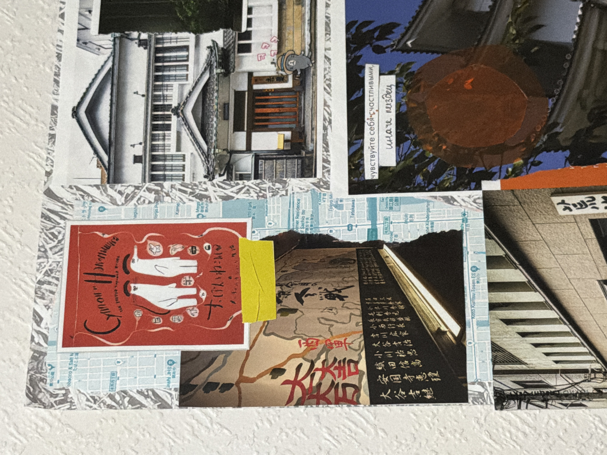 The image is a collage of several photographs and text elements. A prominent element is a red card with two white cat-like figures and Japanese text. To the right of this card is a photograph of a traditional Japanese building with a tiled roof and wooden doors. Below this is another photograph of a Japanese sign with black characters on a white background.
Further down and to the right, there is a photograph of a dark circular object against a blue sky with trees and the roof of a building. A white rectangle with Russian text is superimposed on this image. The Russian text reads: "чувствуйте себя счастливыми, иначе пиздец" which translates to "feel happy, otherwise it's fucked."
To the left, there is a photograph of a street scene with buildings and a map section. There is no discernible information in the image that places this collage in Moscow, Russia.