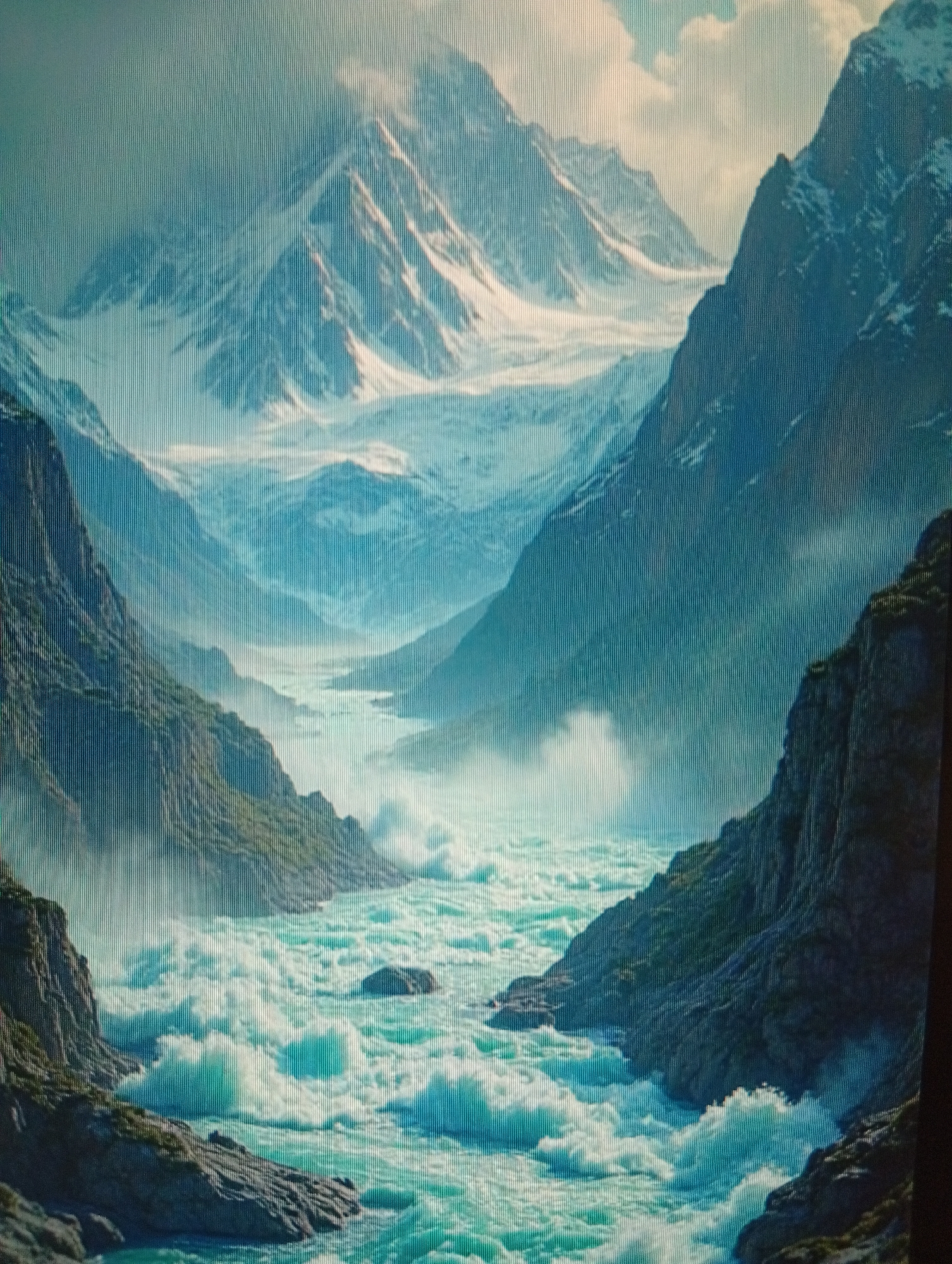 The image depicts a majestic mountain landscape with a powerful river flowing through a valley. The mountains in the background are snow-capped and shrouded in mist, with a glacier visible in the distance. Steep, rocky slopes covered in sparse vegetation line the sides of the valley. The river in the foreground is a vibrant turquoise color, with numerous white rapids and turbulent water. The overall impression is one of wild, untamed natural beauty and immense scale. There are no people or man-made structures visible in the image. The location is described as Unknown, Unknown.
