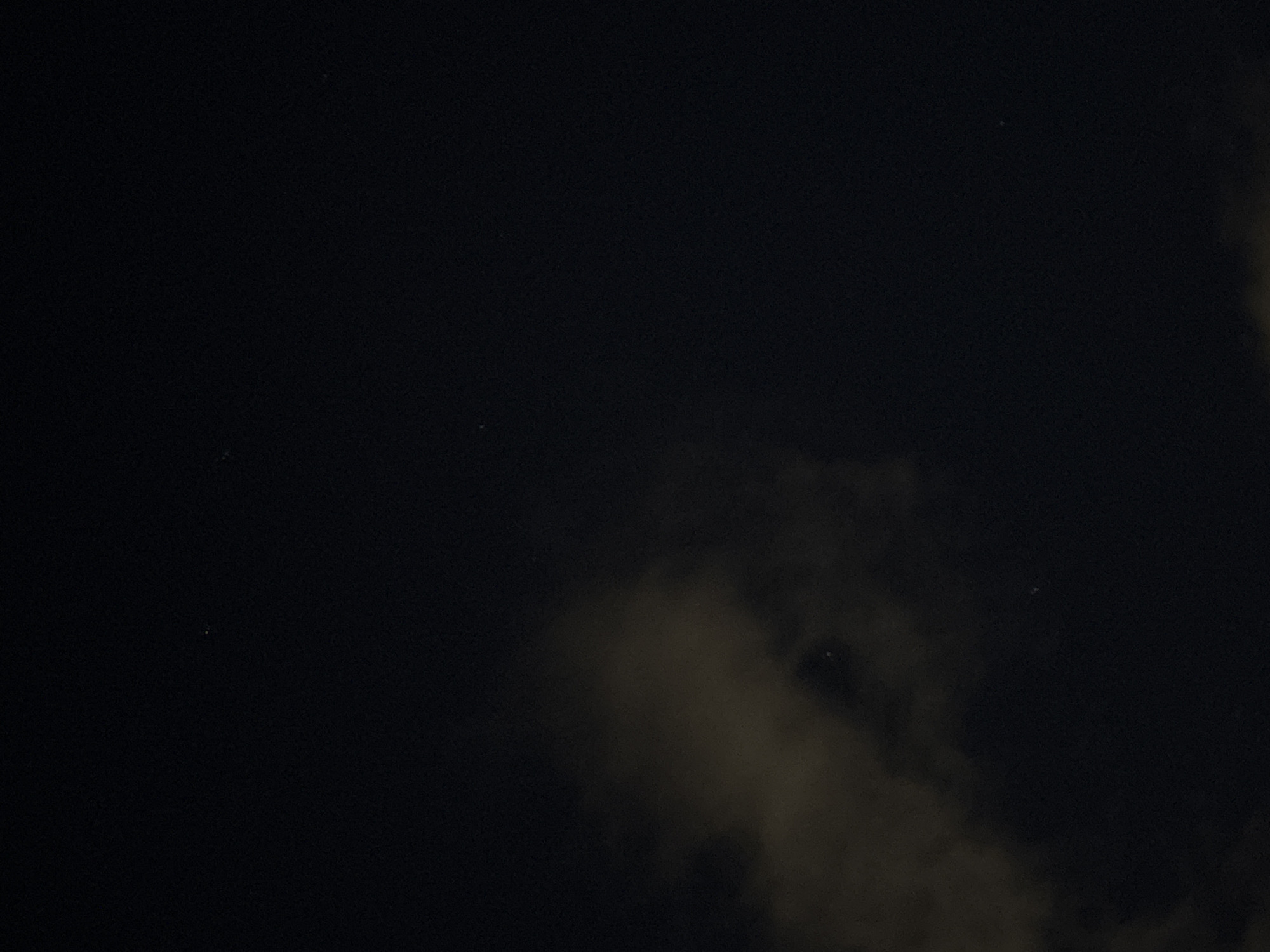 The image shows a night scene in Perm, Russia. The sky is dark, with scattered stars visible. Clouds obscure parts of the sky.