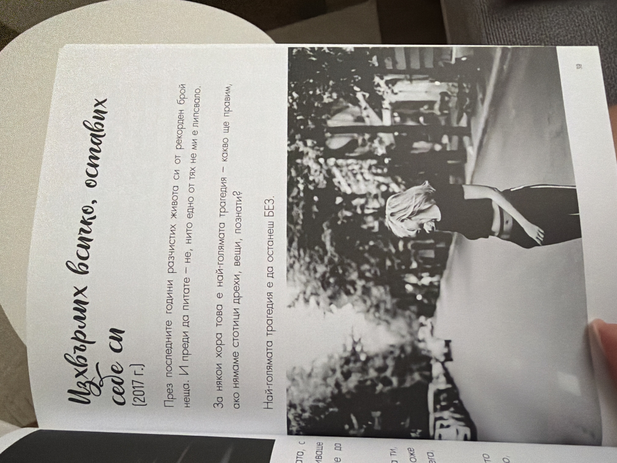The image shows a page from a book with text and a photograph. The text is in Bulgarian and includes a title in a decorative font: "Изхвърлих всичко, оставих себе си" (I threw away everything, I left myself). Below this, in parentheses, is "(2017 г.)" which translates to "(2017 AD)". The text continues with a paragraph discussing a record number of lives and a tragedy. There is a black and white photograph of a woman with blonde hair, wearing a cropped t-shirt and athletic pants, standing on a street lined with trees and parked cars. The photograph is in a cinematic style and the overall tone is somber. The page also has a small number "39" in the bottom right corner, indicating the page number. No specific location in Pazardzhik, Bulgaria, is identifiable from the image.