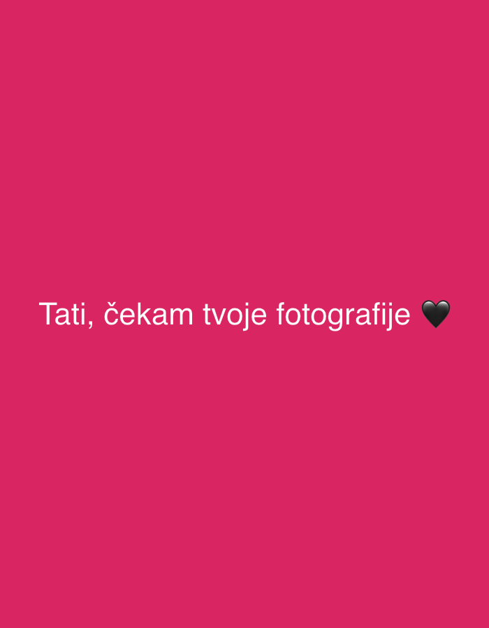 The image shows a pink background with white text that reads "Tati, čekam tvoje fotografije" followed by a black heart emoji. The text translates to "Tati, I'm waiting for your photos" in English. There are no details about the city of Krasnoyarsk, Russia, or any other specific location, people, subjects, objects, actions, or interactions depicted in the image.