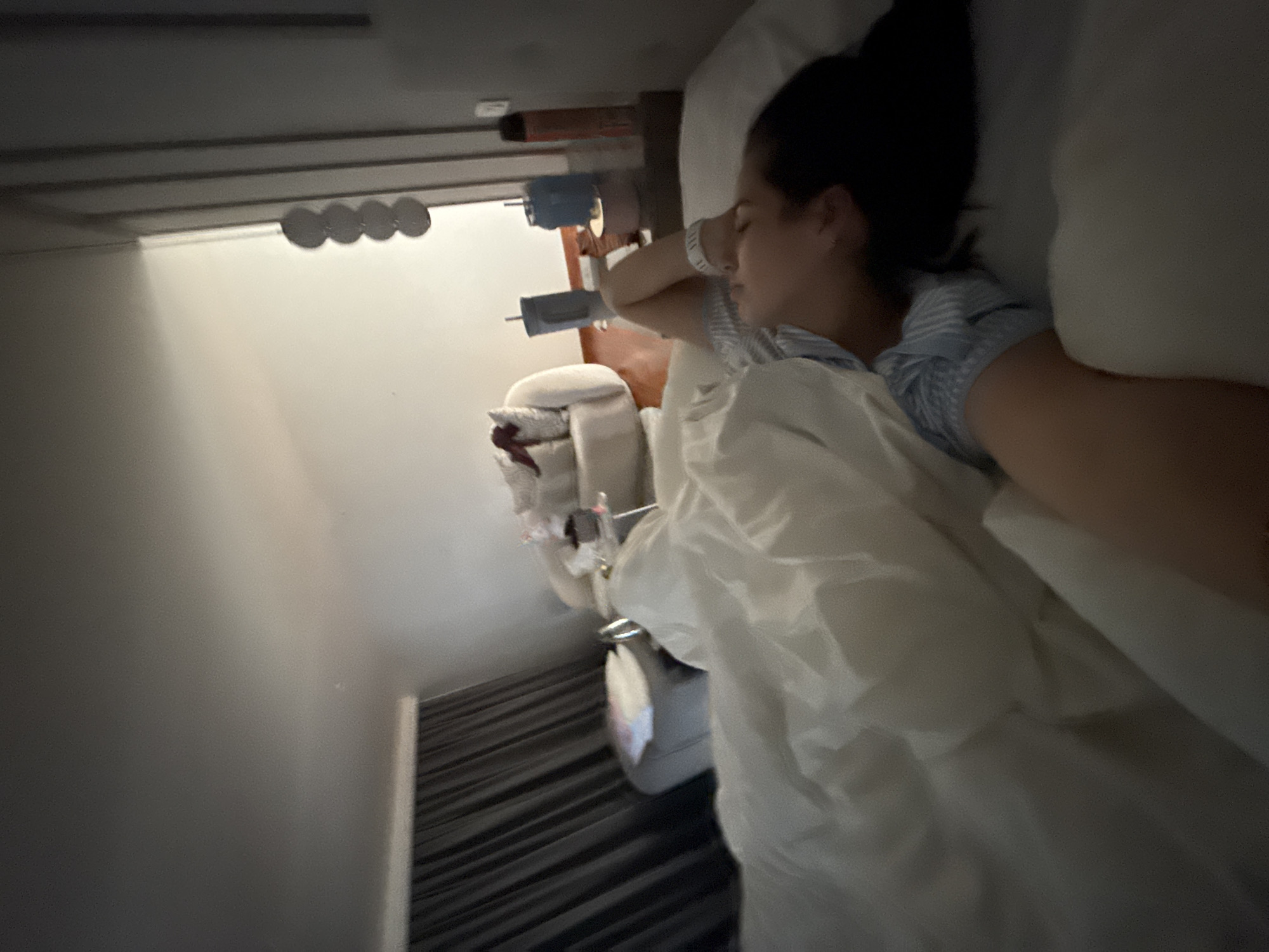 A woman is sleeping in a bed. She is wearing a hospital bracelet. The room appears to be a hospital room. There is medical equipment near the bed. The exact location in San Bernardino Tlaxcalancingo, Mexico cannot be determined from the image.