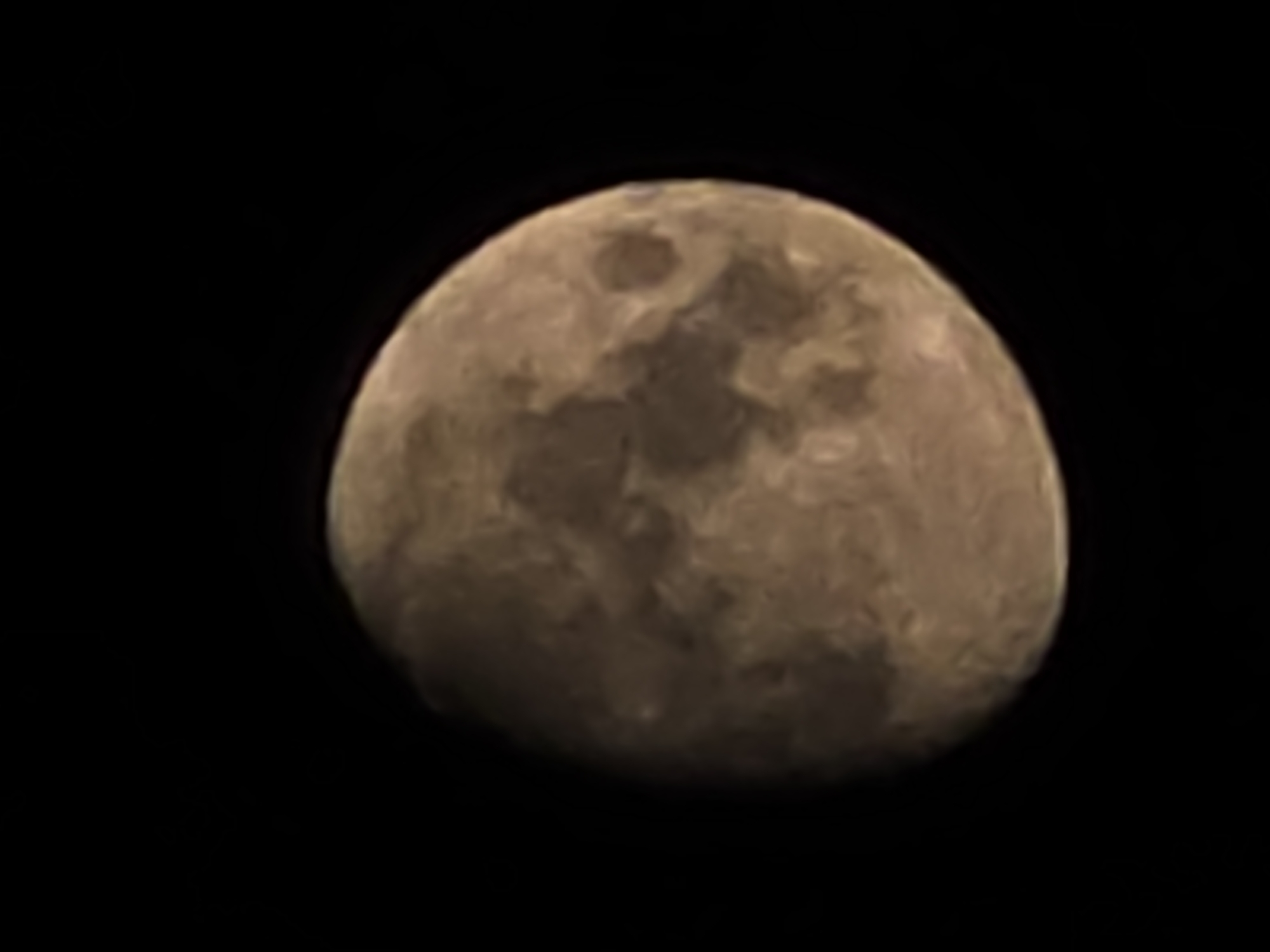 A grainy image shows a full moon against a black sky. The moon is off-center, positioned to the right side of the frame. Its surface texture is visible, showing darker and lighter areas that suggest craters and other lunar features. No other objects or details of a location are visible, making it impossible to identify the scene as Warsaw, Poland or any other specific location.