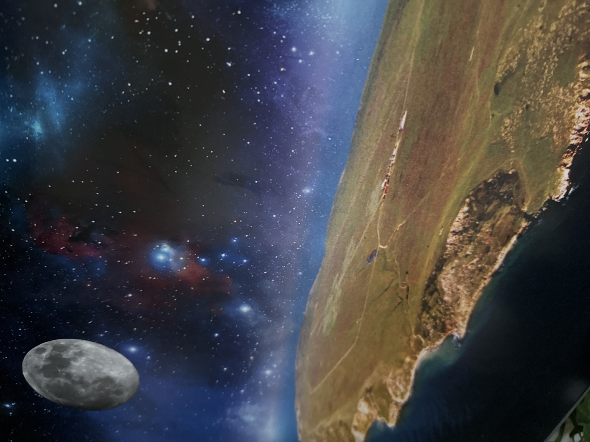 The image depicts a composite scene of space with a planet and moon. The left side shows a starry expanse with nebulae and a gray moon in the lower left. The right side features a planet's surface, covered in green vegetation and bordered by a coastline. The scene is tilted, creating a dynamic perspective. Based on the vegetation and topography, this location is not recognizable in the city of Ново-Никольское, Russia.
