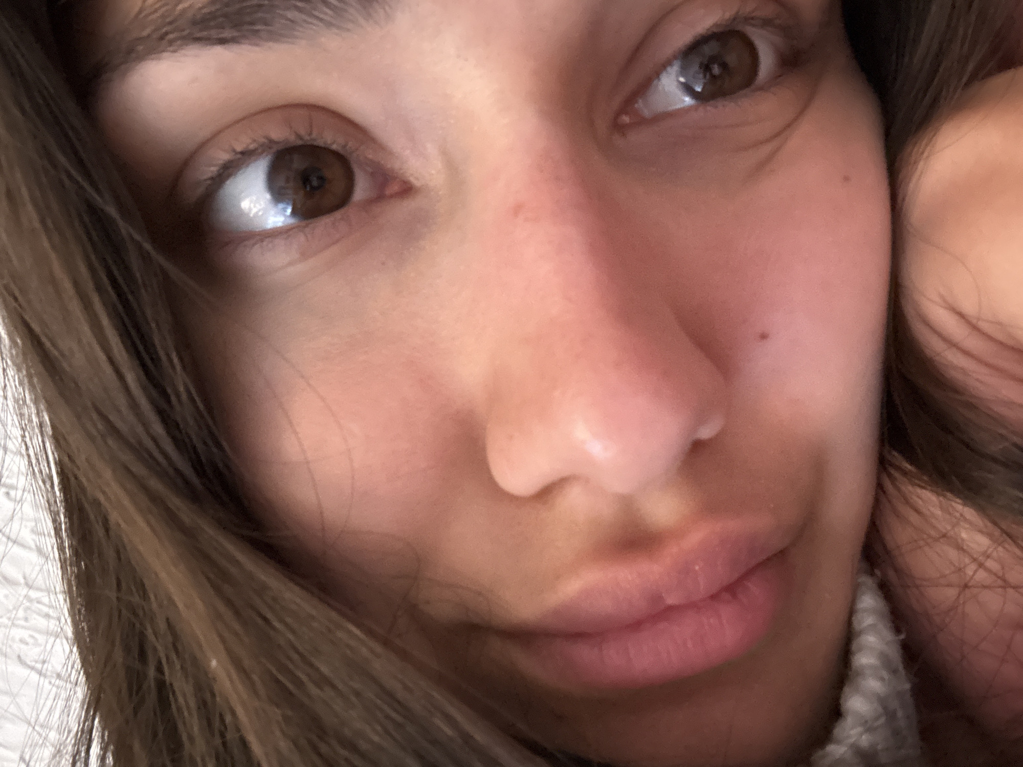 A close-up photograph captures a person's face. The individual has light skin, brown eyes, brown hair, and pink lips. The background is blurry and out of focus. No information suggests a location in Sutomore, Montenegro.
