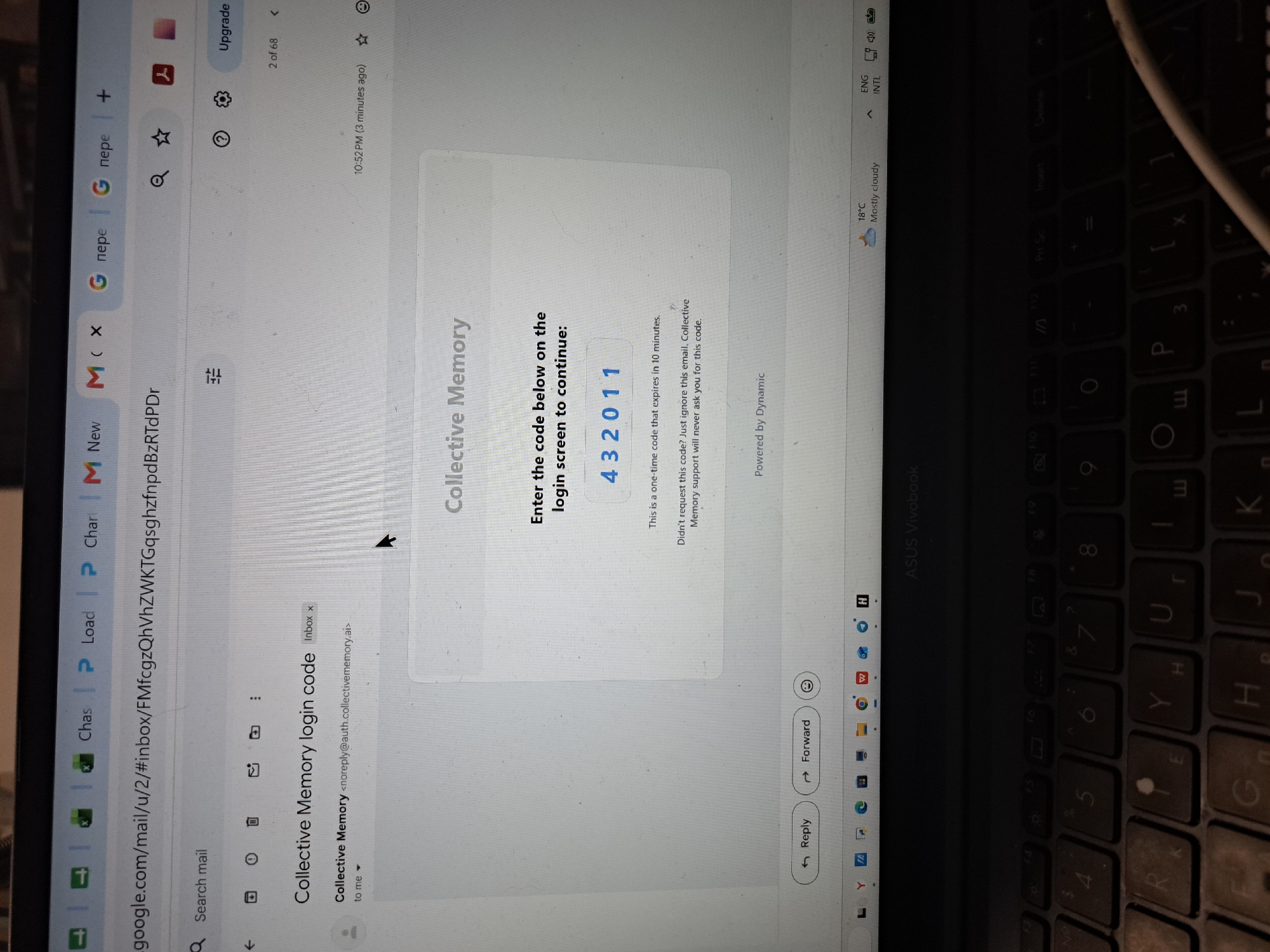 The image shows a laptop screen displaying an email from "Collective Memory" with a login code. The email contains the code "432011" and a message stating it's a one-time code that expires in 10 minutes. The laptop is open, and a portion of the keyboard is visible at the bottom of the image. The background is dark, suggesting it might be an indoor setting. The time displayed on the system tray is 10:52 PM. There is no information about the location of Gus-Khrustalny, Russia, in this image.