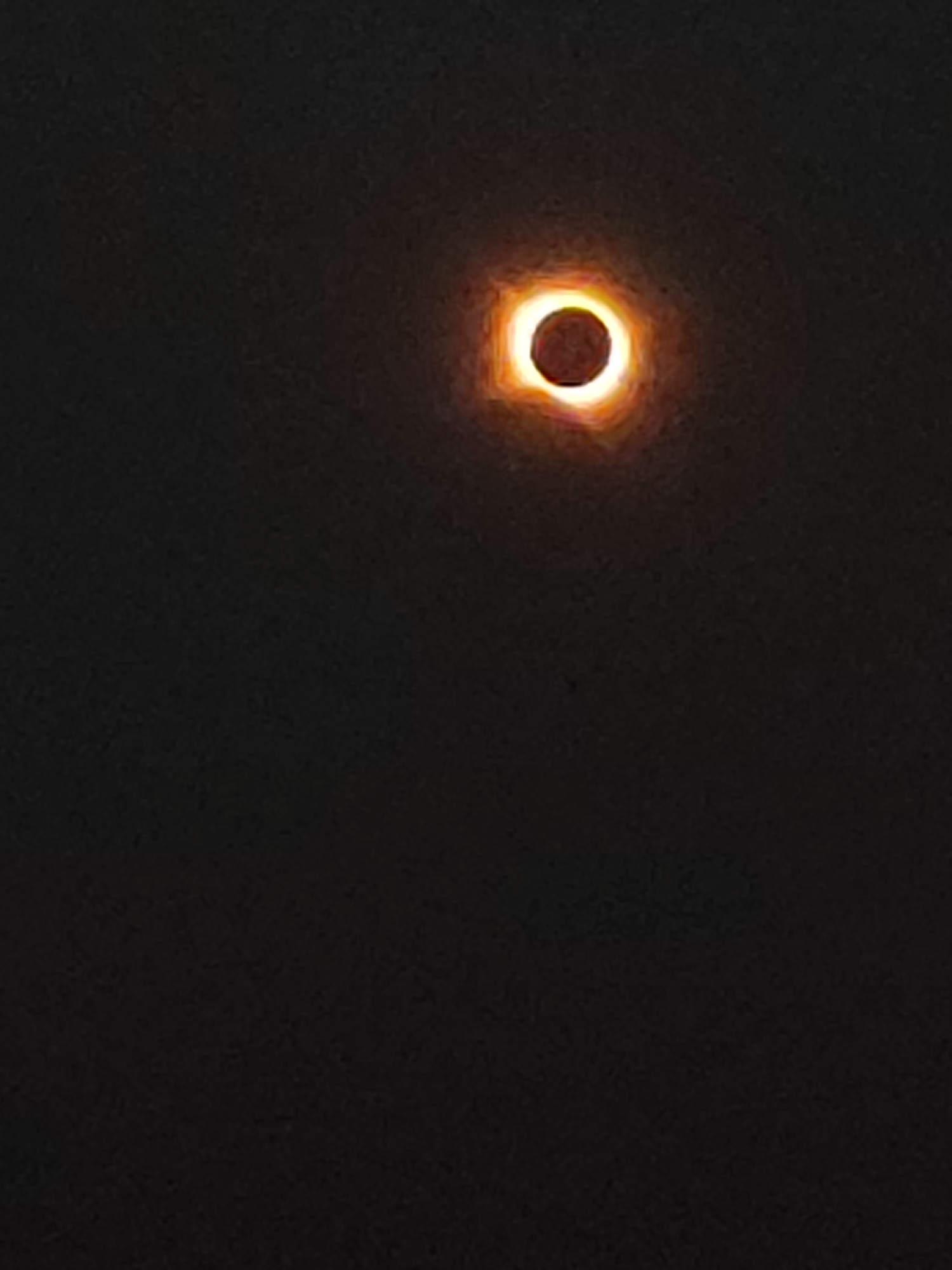 The image shows a partial solar eclipse occurring in the sky over Autillo de Campos, Spain. The sun is partially obscured by the moon, creating a ring of light around the darker lunar disc. The sky is dark, suggesting the eclipse is in progress. There are no people, buildings, or other objects visible in the frame, focusing the viewer's attention solely on the astronomical event.