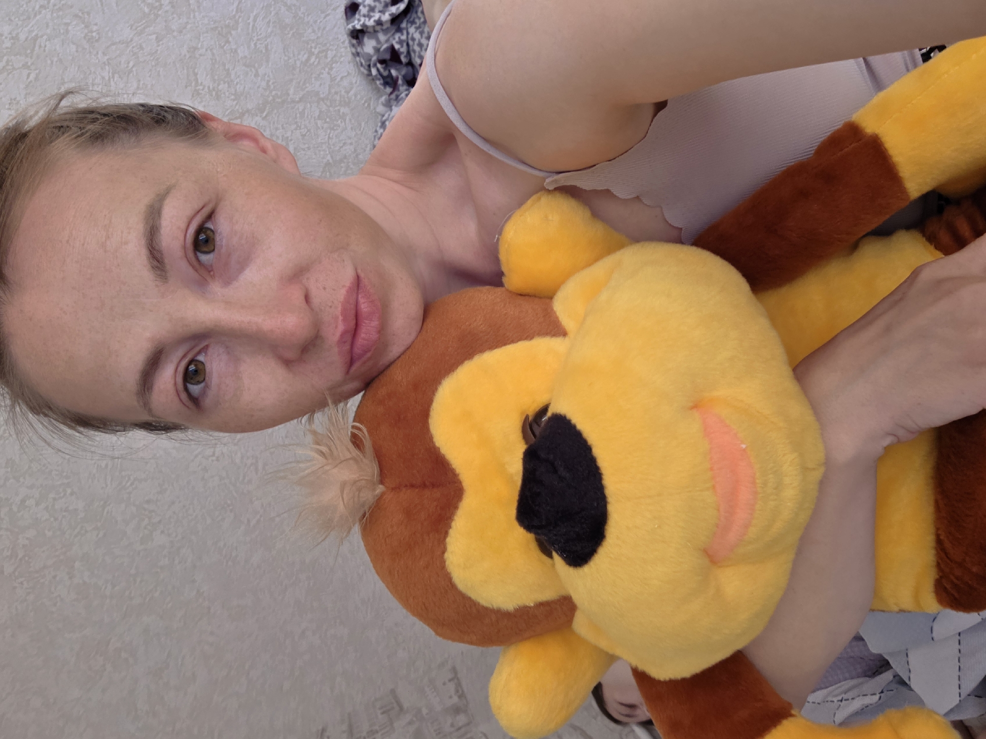 A woman is holding a stuffed monkey. The location is likely in the city of Chaikovsky, Russia.