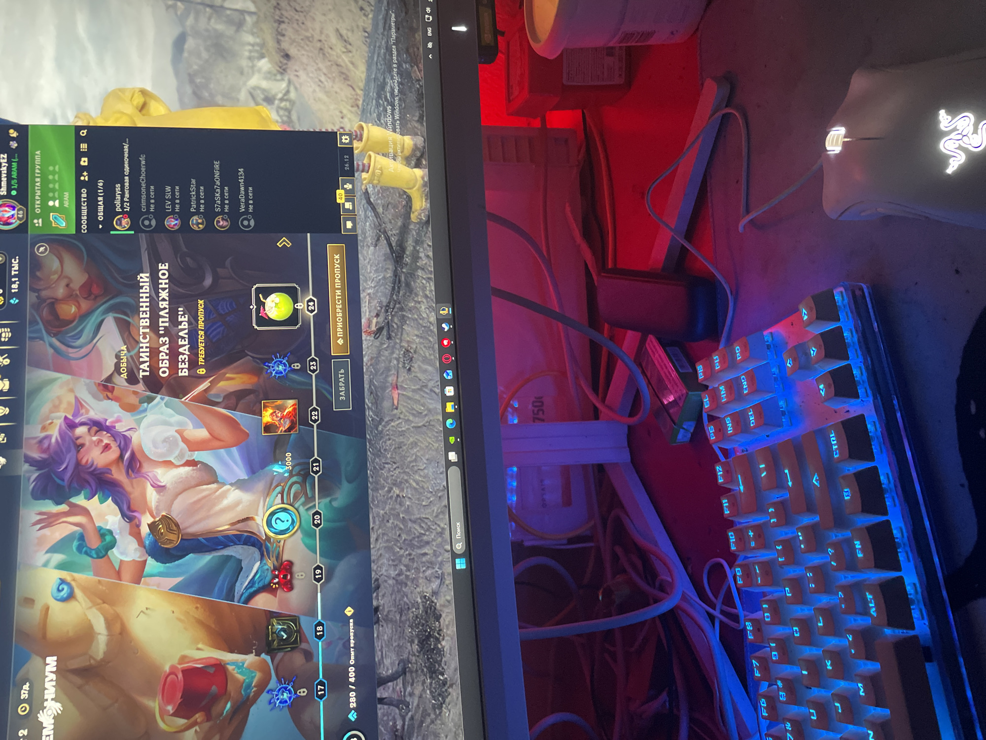 The image displays a computer monitor with a game interface visible. The game appears to be a fantasy-themed online game, possibly a MOBA, given the character art and interface elements. The monitor is curved and is centrally positioned in the frame. On the screen, there are multiple character portraits, icons, and text in Russian, indicating the game is likely set to that language. The lower part of the image shows a portion of a keyboard with illuminated keys and a white gaming mouse. The overall lighting suggests an indoor environment, with the glow from the monitor and keyboard being the primary light sources, casting colorful reflections on the surrounding desk and equipment.
There is no indication of the city of Neoi Epivates, Greece, or any external environmental elements in the provided image. The scene is entirely focused on the computer setup and the game being played.