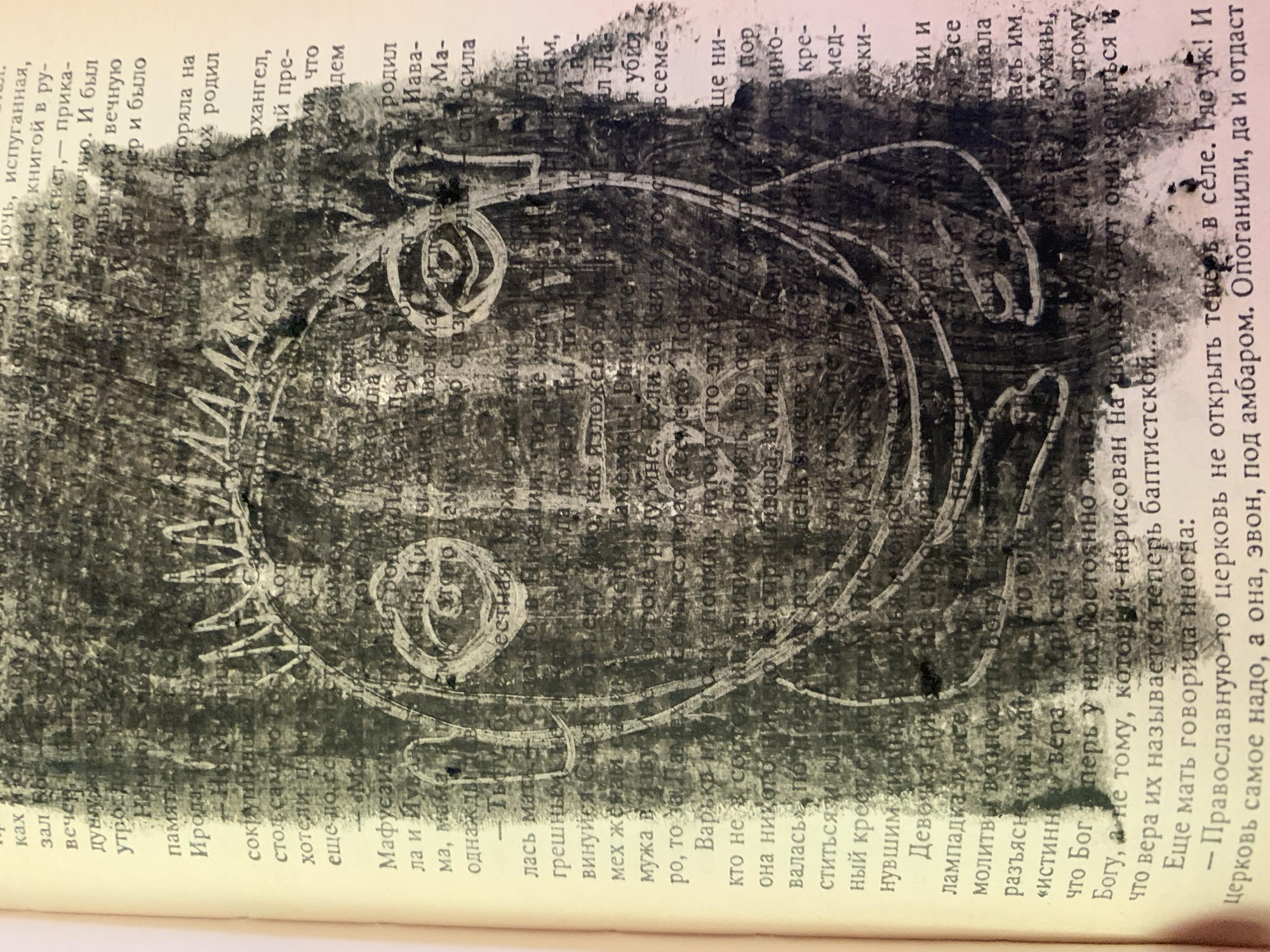 The image shows an open book with a textured, dark overlay, obscuring most of the text and illustration. The overlay appears to be a rubbing or charcoal drawing, possibly of a stylized, circular face with concentric circles and abstract shapes within it, resembling a fish or a mandalain design.
The visible text, which is primarily in Russian, mentions several names such as "Ирода," "Миха," "Ламеха," "Мафусайла," and "Иувала." There are also references to religious concepts like "архангел," "Христа," "иконы," and "церковь." The text discusses biblical genealogy, prayers, and church matters, including a statement about the church not being open and being located under a barn.
The overall impression is one of layered history and mixed media, where a printed text is partially covered by a dark, gestural drawing. The obscured nature of the content suggests a deliberate artistic choice to blend or transform the original material. The location context of "Ganino, Russia" hints at a specific regional or personal narrative connected to the drawn text.