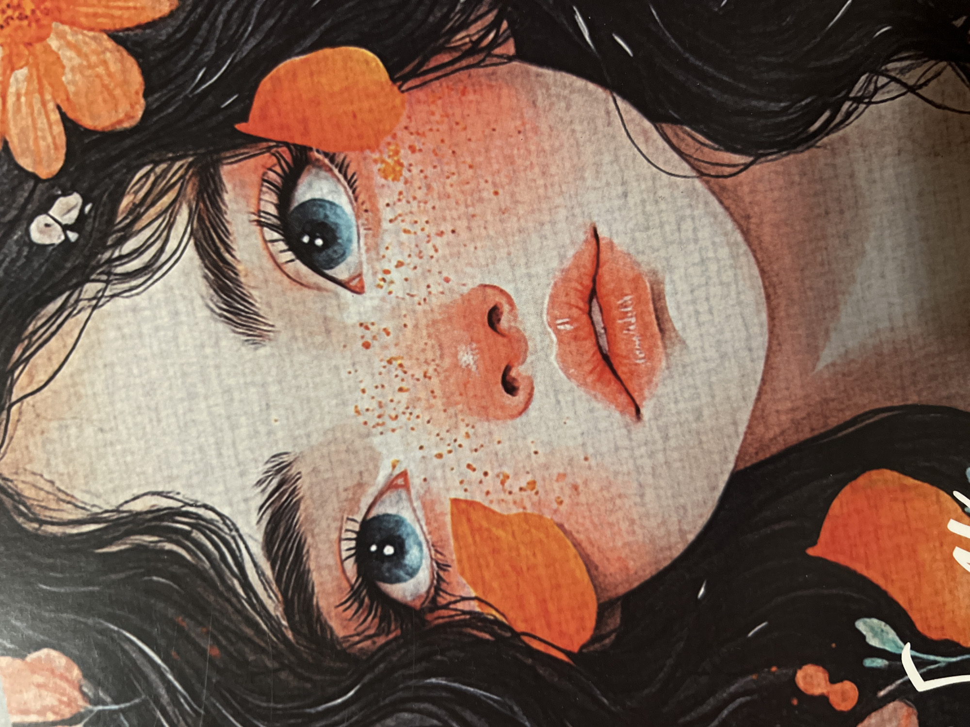 The image is a close-up, watercolor-style illustration of a young girl's face, possibly a portion of a larger artwork. She has large, striking blue eyes with long, dark eyelashes and defined eyebrows. Her cheeks are adorned with delicate orange freckles, and her lips are painted a vibrant coral shade. Orange petal-like shapes are artfully placed around her face, some nestled in her dark, wavy hair, and others appearing to float near her cheeks. There are also hints of greenery at the bottom left of the image, suggesting a natural or floral theme. The overall aesthetic is whimsical and artistic, with a soft, textured appearance reminiscent of watercolor paper.
There is no information in the image that would allow for the determination of its location in the city of Minsk, Belarus, or any specific geographical context.