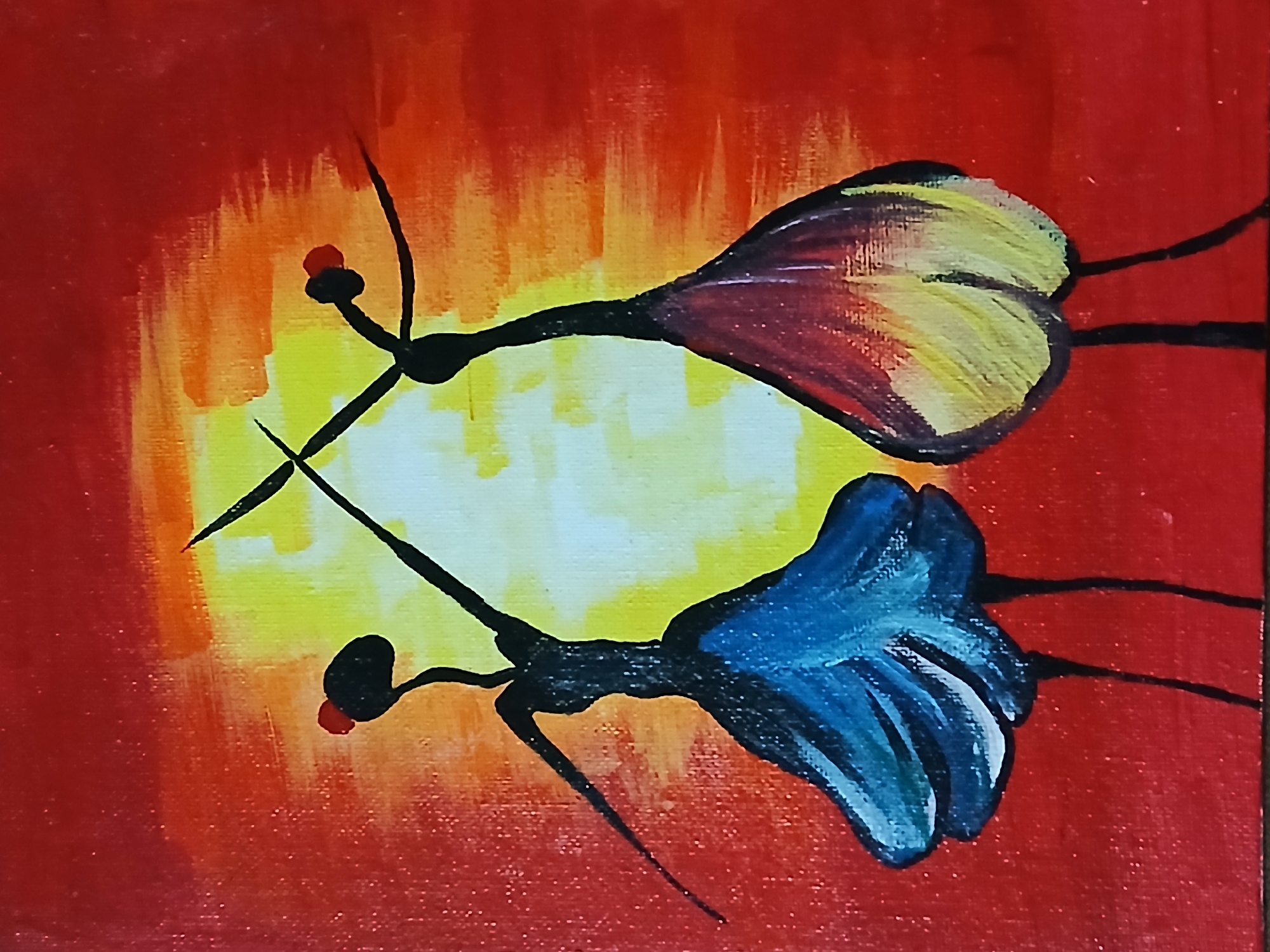The image is an abstract painting featuring two stylized figures, possibly dancers or ethereal beings, set against a vibrant, fiery background. The background depicts a luminous gradient, with a bright central area of yellow and white radiating outwards into streaks of orange, which then blend into a deep, rich red. This color scheme strongly suggests either a sunrise or a sunset.
The two figures are minimalist in design, with slender, black, stick-like bodies and small, round heads, each topped with a tiny red accent. They appear to be in dynamic motion, suggesting a dance or flight. The upper figure, oriented towards the upper left, has a flowing form resembling a dress or wings painted in broad strokes of yellow, orange, and maroon. The lower figure, angled towards the lower right, features a similar flowing form in shades of blue and white. Their limbs are extended gracefully, emphasizing their movement.
The painting style uses visible brushstrokes, particularly evident in the background's blending colors and the textured appearance of the figures' forms, giving it an expressive quality. The overall mood conveyed by the vibrant colors and fluid forms is one of energy, grace, and warmth. There is no visible text in the media file. The context of Bengaluru, India, refers to the image's origin or capture location rather than a scene depicted within the abstract artwork.