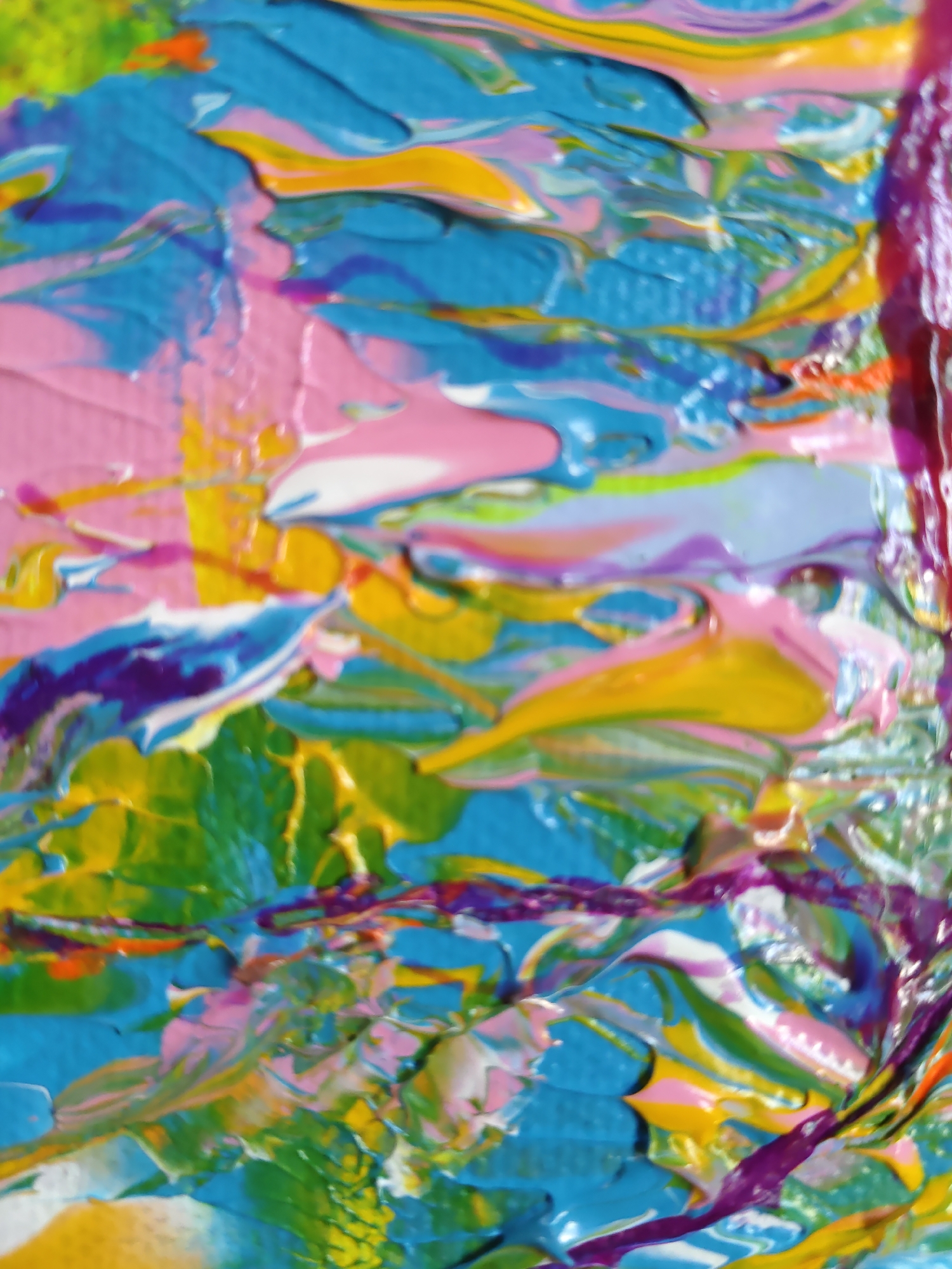 The image is a close-up, abstract photograph of thick, impasto oil paint applied to a surface. The paint is layered and textured, with visible brushstrokes and swirls of various colors including bright pink, various shades of blue, yellow, green, and hints of purple and orange. The texture of the paint creates highlights and shadows, giving the image a sense of depth. There are no recognizable objects, people, or environments depicted. The image is an abstract artwork. There is no information in the image that can place it in Rostov-on-Don, Russia, or any other specific location.