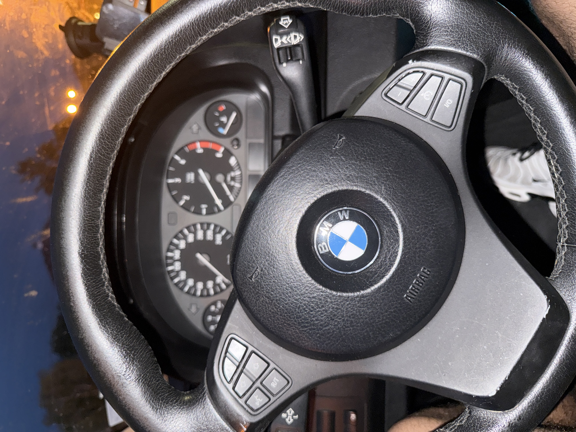 The image shows the interior of a BMW car. The steering wheel, instrument cluster, and a portion of the center console are visible. The steering wheel has the BMW logo in the center and control buttons on either side. The instrument cluster features speedometer, tachometer, and other gauges. The location of the image is unknown, and there is no indication of Antimovo, Bulgaria. There are no people visible in the image.