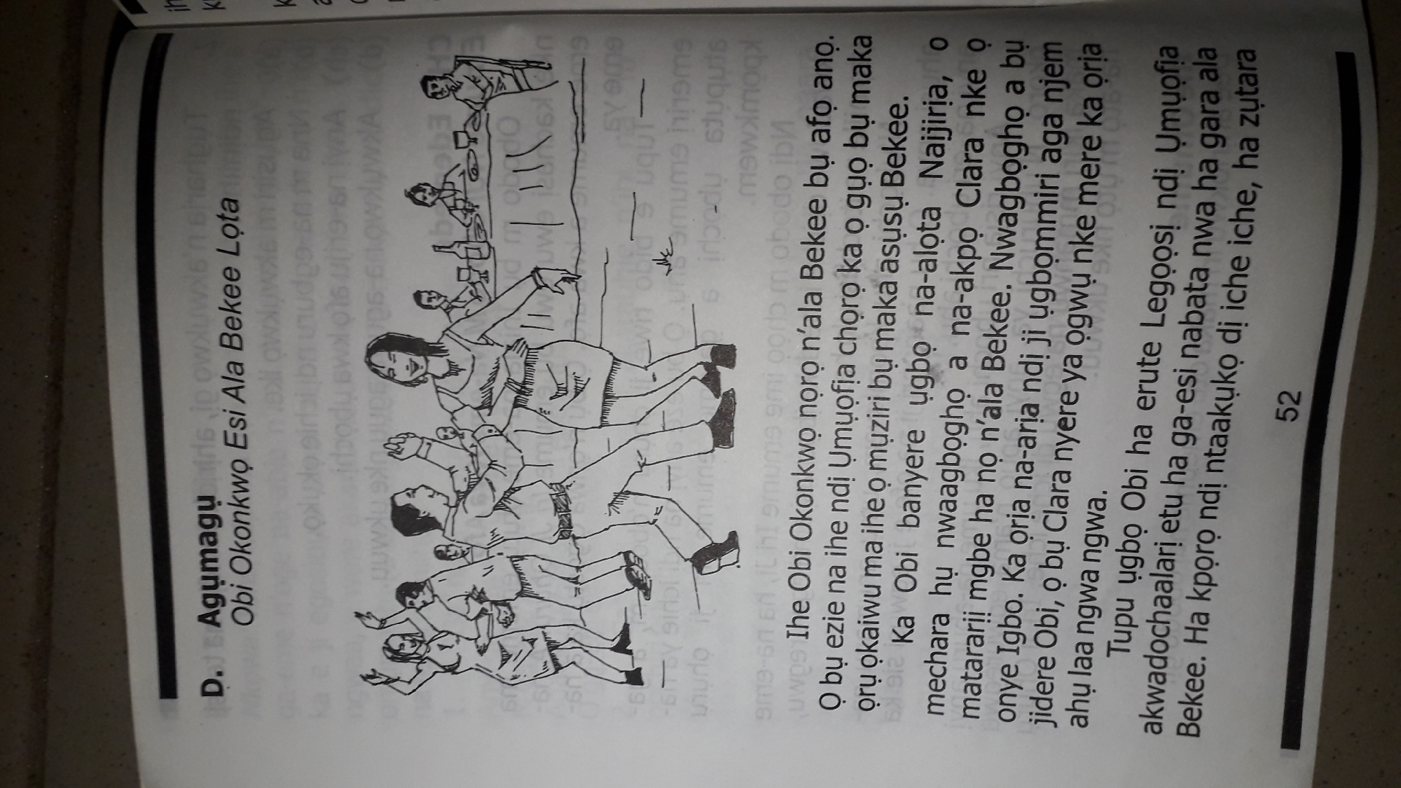 The image shows a page from a book with text and an illustration. The text is in Igbo. The illustration depicts a group of people dancing and others seated at a table. The page number "52" is visible at the bottom. The text discusses a character named Obi Okonkwo. Based on the information provided, the book's content relates to a story that may be set in or involve Nkpor, Nigeria. However, the image itself does not contain any visual elements that specifically indicate the location of Nkpor, Nigeria. The scene is an indoor setting, likely a gathering or party.