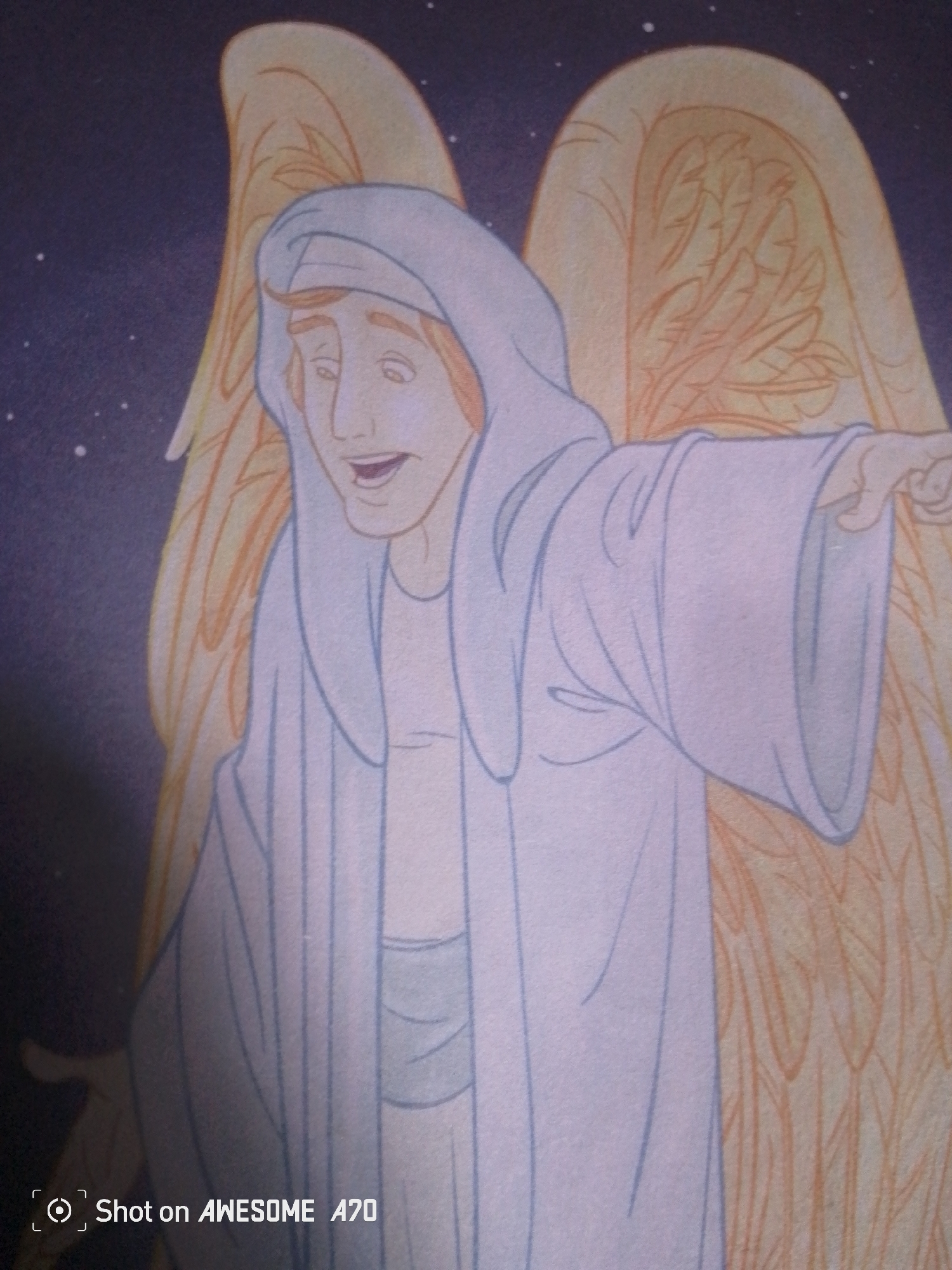 A drawing of an angelic figure with light skin, wearing a light blue hooded robe, stands against a dark purple, starry background. The figure has orange hair and appears to be smiling with its mouth open. Large, golden wings with detailed feathering extend from its back. The figure's right hand is extended outwards, pointing to the right. A watermark in the lower left corner reads "Shot on AWESOME A70". The image does not depict any specific location within the city of Jalingo, Nigeria.