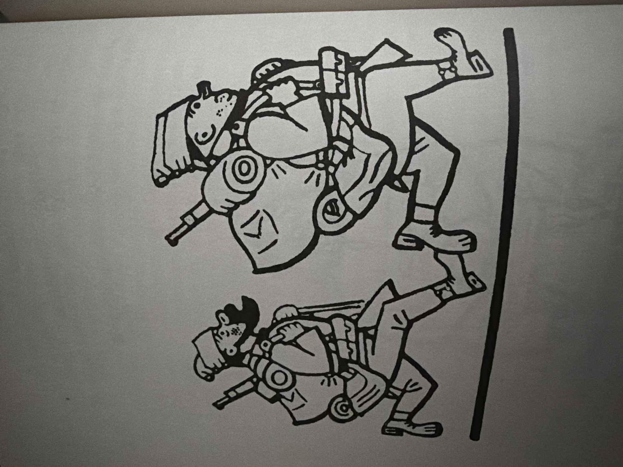 The image shows a black and white illustration of two figures running from left to right across a horizontal line. Both figures are depicted in a simplified, cartoonish style, wearing hats and carrying large backpacks with rifles strapped to them. The figure on the left has a beard and appears to be looking forward. The figure on the right is slightly larger and also appears to be looking forward, with a more prominent nose. They are running on what appears to be a road or a path. The background is a plain, light gray color, indicating a lack of environmental detail. There is no identifiable context that places this image specifically in the city of Pazardzhik, Bulgaria.