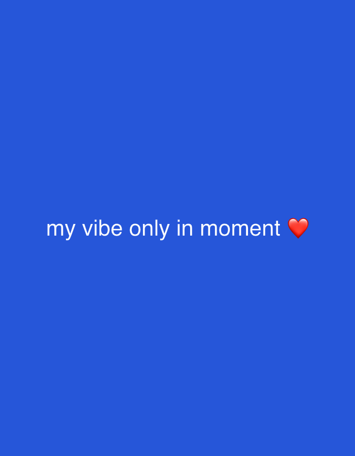 The image displays a solid blue background. White text, centered horizontally, reads "my vibe only in moment", followed by a red heart emoji. No people, discernible objects beyond the text and emoji, actions, or interactions are present. The environment is a uniform color field, providing no visual cues to identify a specific location within the city of Munggu, Indonesia.