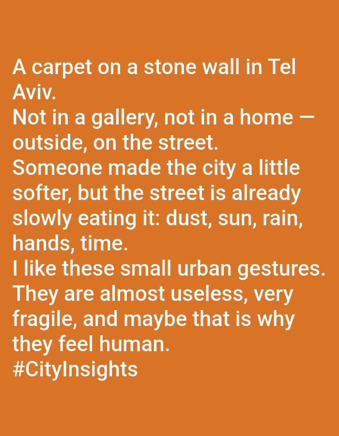 The image shows a text-based artwork. The text describes a carpet on a stone wall in Tel Aviv, Israel, which is not located in a gallery or a home but is instead outside on the street. The text suggests someone placed the carpet there to soften the urban environment, but elements like dust, sun, rain, hands, and time are slowly affecting it. The observer appreciates these small urban gestures, noting they are almost useless, fragile, and perhaps that's why they feel human. The text ends with the hashtag #CityInsights. The text is displayed on an orange background.