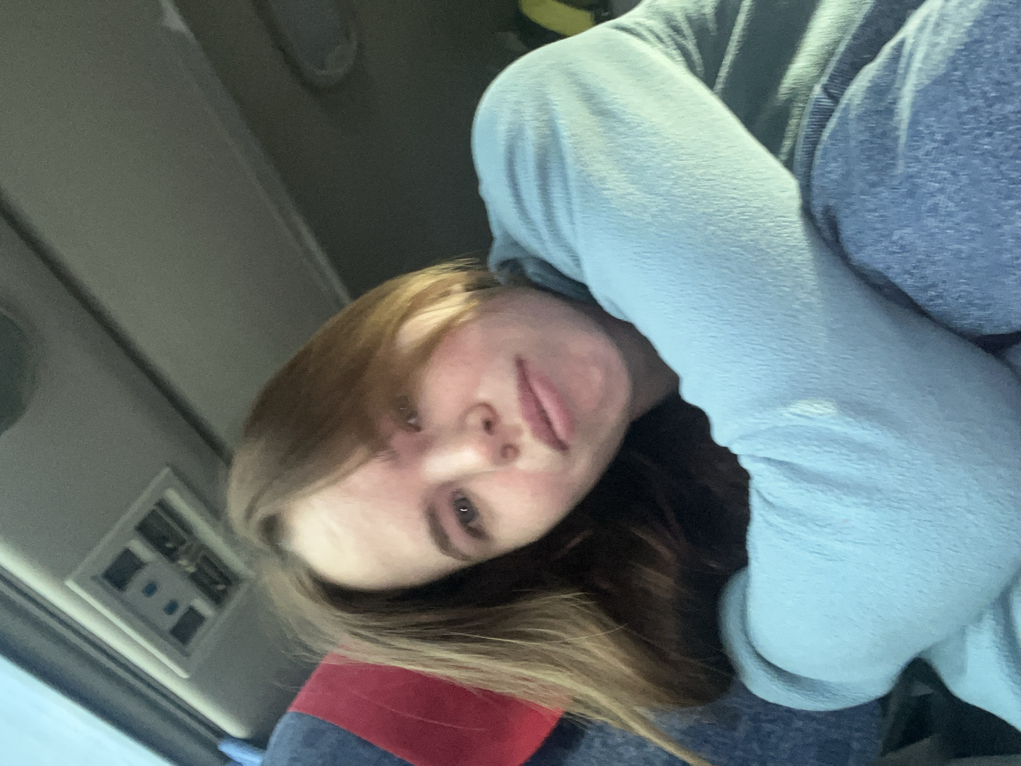 A selfie taken inside a vehicle. The subject, a young woman with long brown hair, is looking at the camera. The background shows the interior of the vehicle, including the ceiling and an air conditioning vent. The location in Berezniki, Russia cannot be determined from the image.