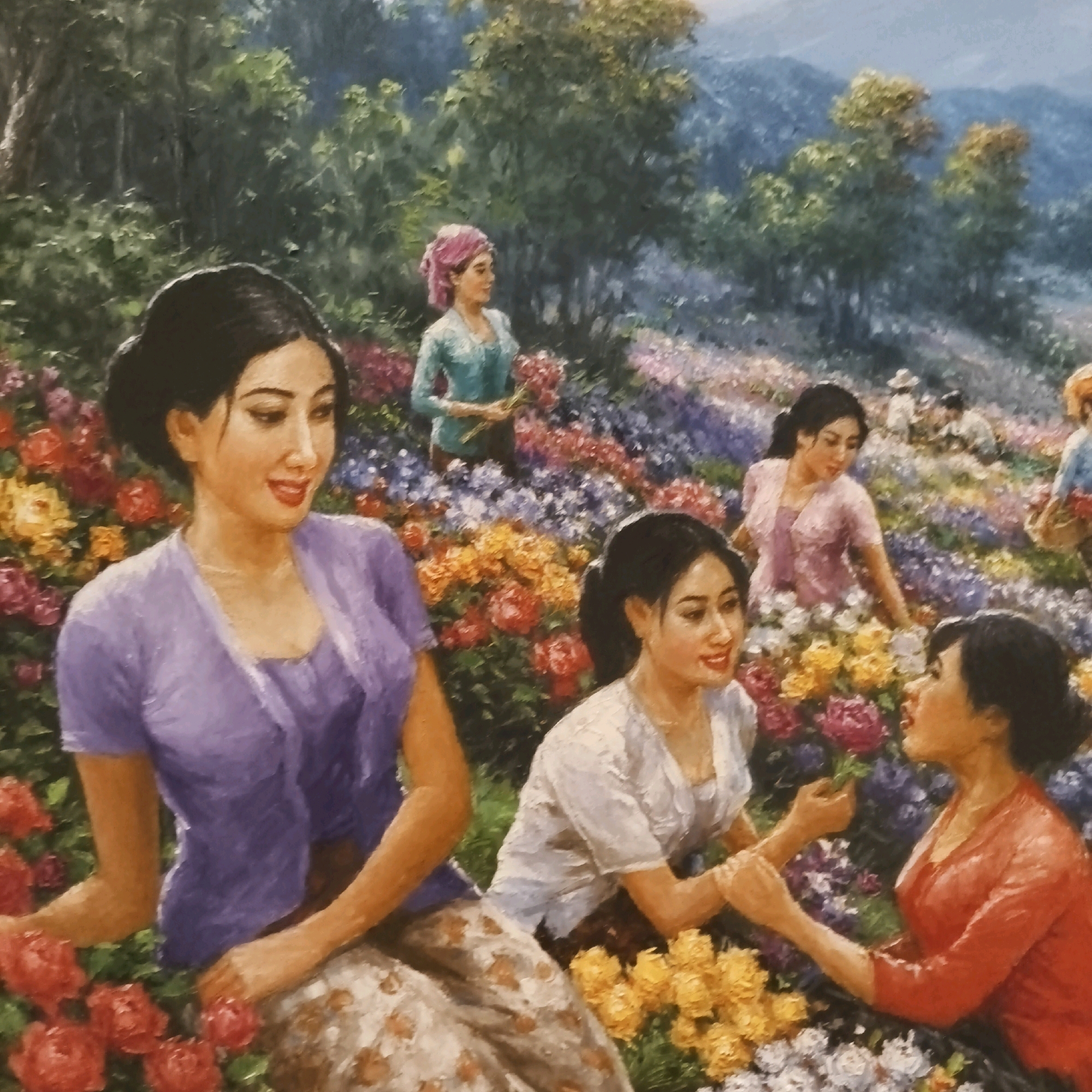 The image is a painting depicting a group of women in a flower field. The women are of Asian descent, dressed in traditional clothing, and appear to be harvesting or admiring flowers. The landscape is lush with rolling hills in the background and a vibrant array of colorful flowers in the foreground, including reds, oranges, purples, and yellows. The lighting suggests a bright, daytime setting.
The painting does not contain any elements that would allow for the identification of a specific location within South Jakarta, Indonesia.