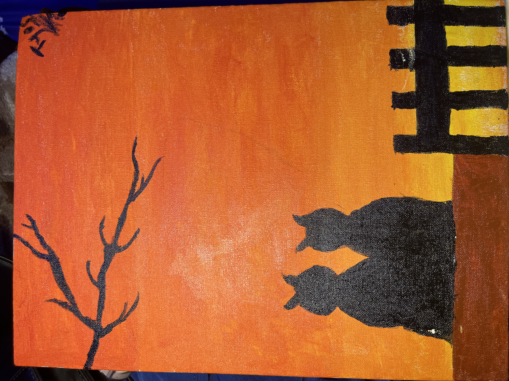 The image is an amateur painting depicting a silhouette of two cats sitting on a wall, with a tree branch on the left and a building fragment on the right, all set against an orange and yellow sky. The painting does not contain enough information to determine its location in Jos, Nigeria.