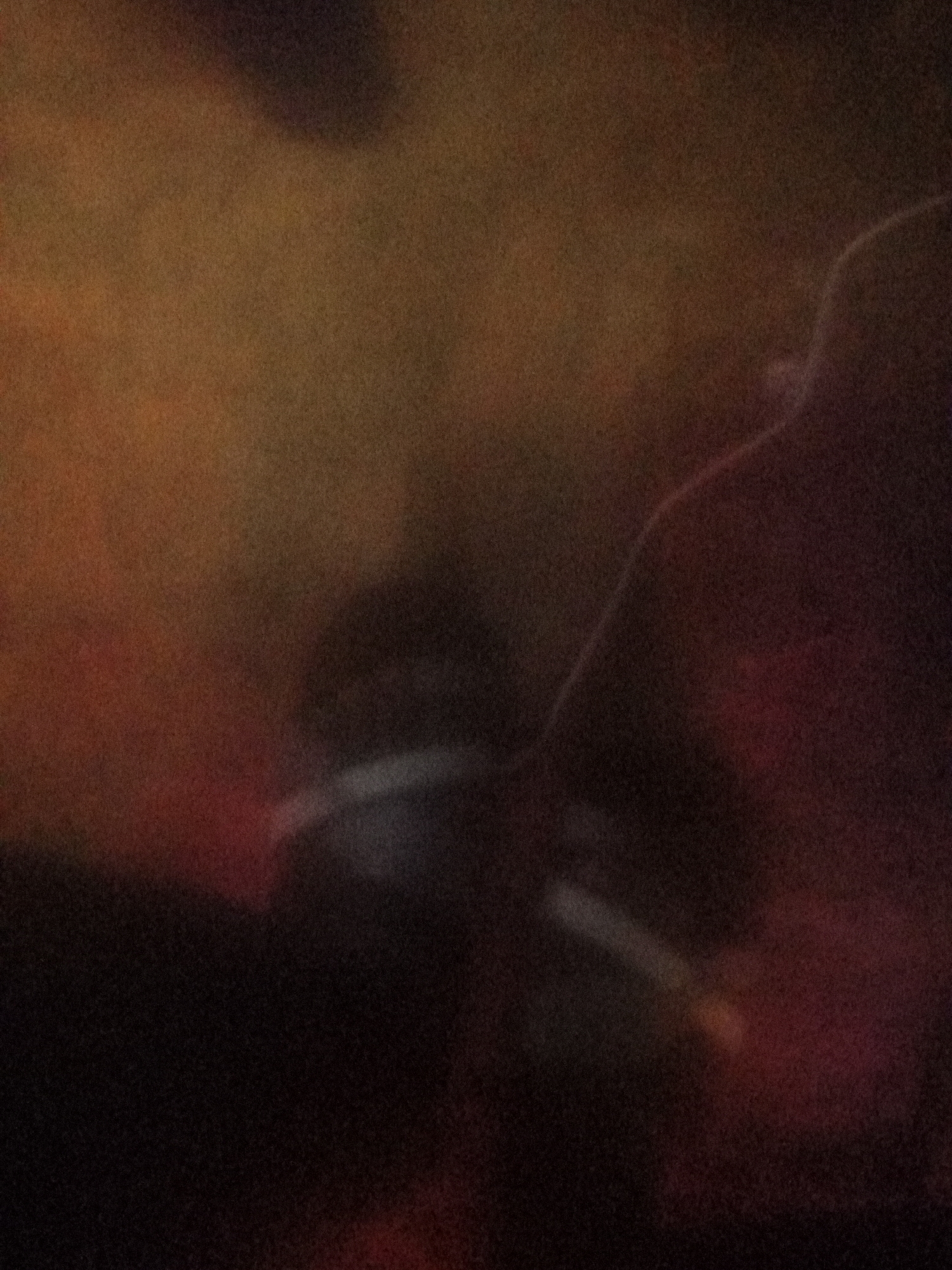 The image depicts an out-of-focus, dimly lit scene with abstract shapes and colors. The dominant colors are shades of brown, orange, and red, with some darker areas. There is a suggestion of a curved, lighter-colored object in the center, possibly a limb or a piece of fabric. The overall impression is of a low-resolution, atmospheric photograph with no discernible landmarks or specific details that could place it within Jalingo, Nigeria, or any other location.