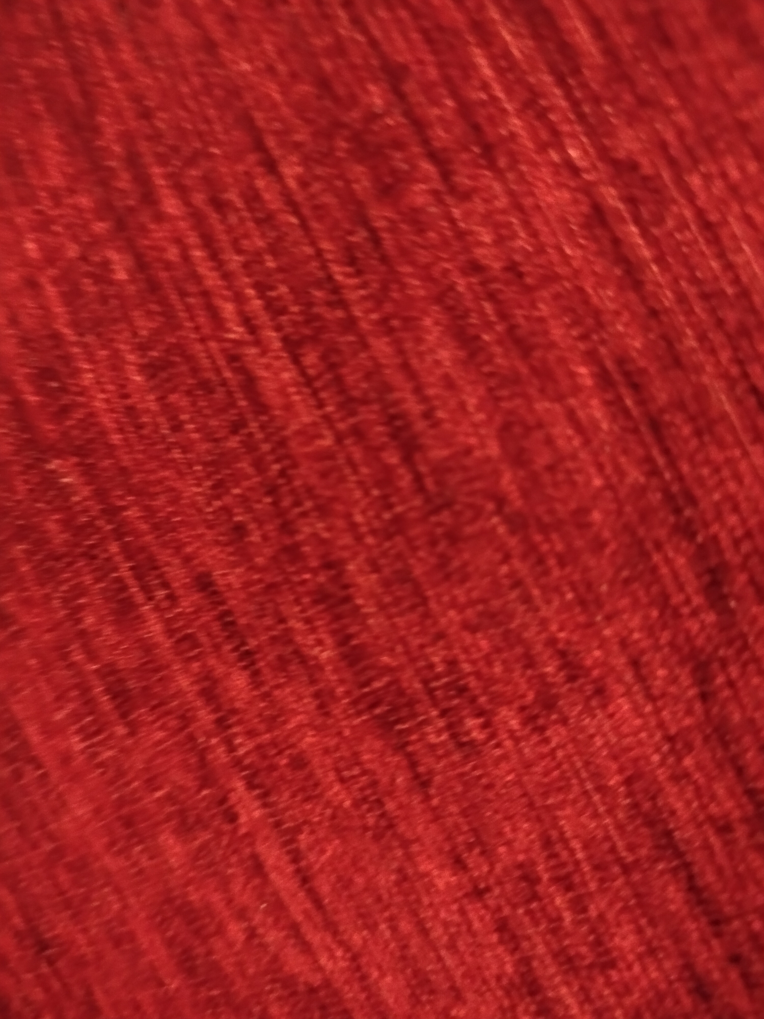 The image shows a close-up view of red woven fabric. The material appears textured with an unclear weaving pattern. There are no people, actions, or interactions visible in the image. Based on the limited information, it is not possible to determine a location in Yerevan, Armenia.