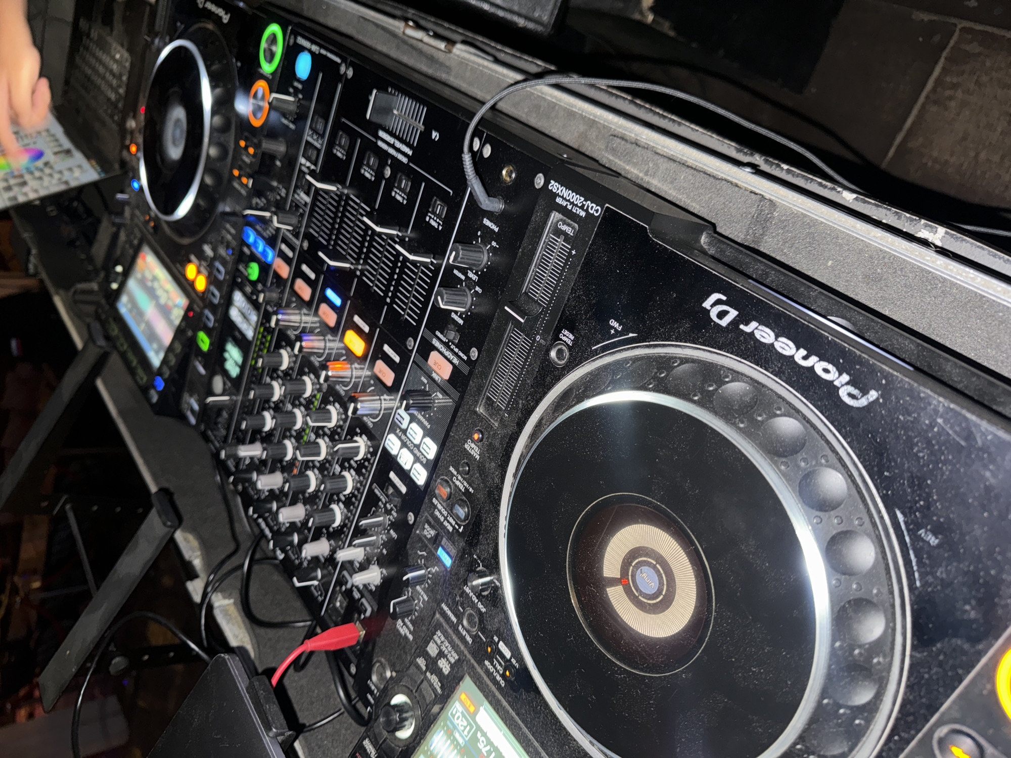 The image shows a Pioneer DJ setup, including a mixer and two CDJ-2000NXS2 multi-players. The setup is dusty. The photo is taken at an angle. The city of Moscow, Russia, is not discernible from this image.
