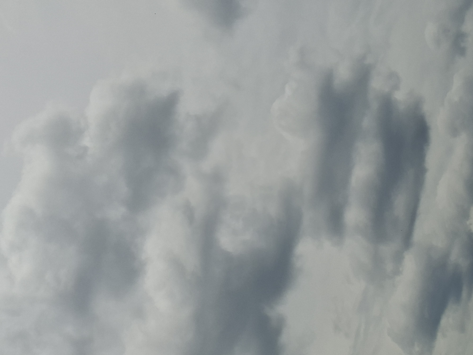 The image depicts a cloudy sky, with various shades of gray clouds filling the frame. The clouds appear to be dense and layered, suggesting overcast conditions. There are no discernible people, subjects, objects, or actions visible in the image. The scene is devoid of any urban or environmental context, making it impossible to determine a specific location within the city of Detelina, Bulgaria, or any other geographical setting. The image is a close-up of clouds and offers no information about the surrounding environment.