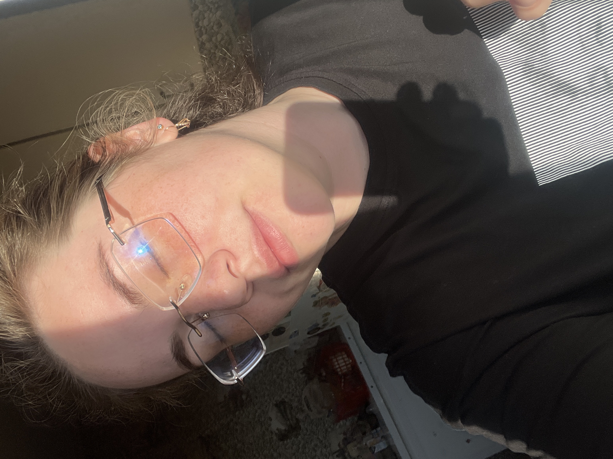A close-up photograph depicts a person wearing glasses and a dark-colored shirt. The person is positioned at an angle, with part of the face brightly illuminated. The location is indicated as Сосново, Russia.