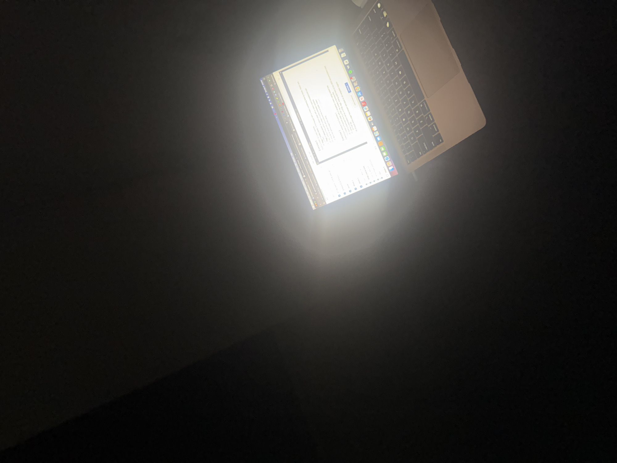 A laptop is illuminated in the darkness. The laptop is open with a document displayed on the screen. The location, Ihiagwa, Nigeria, cannot be determined from the image.