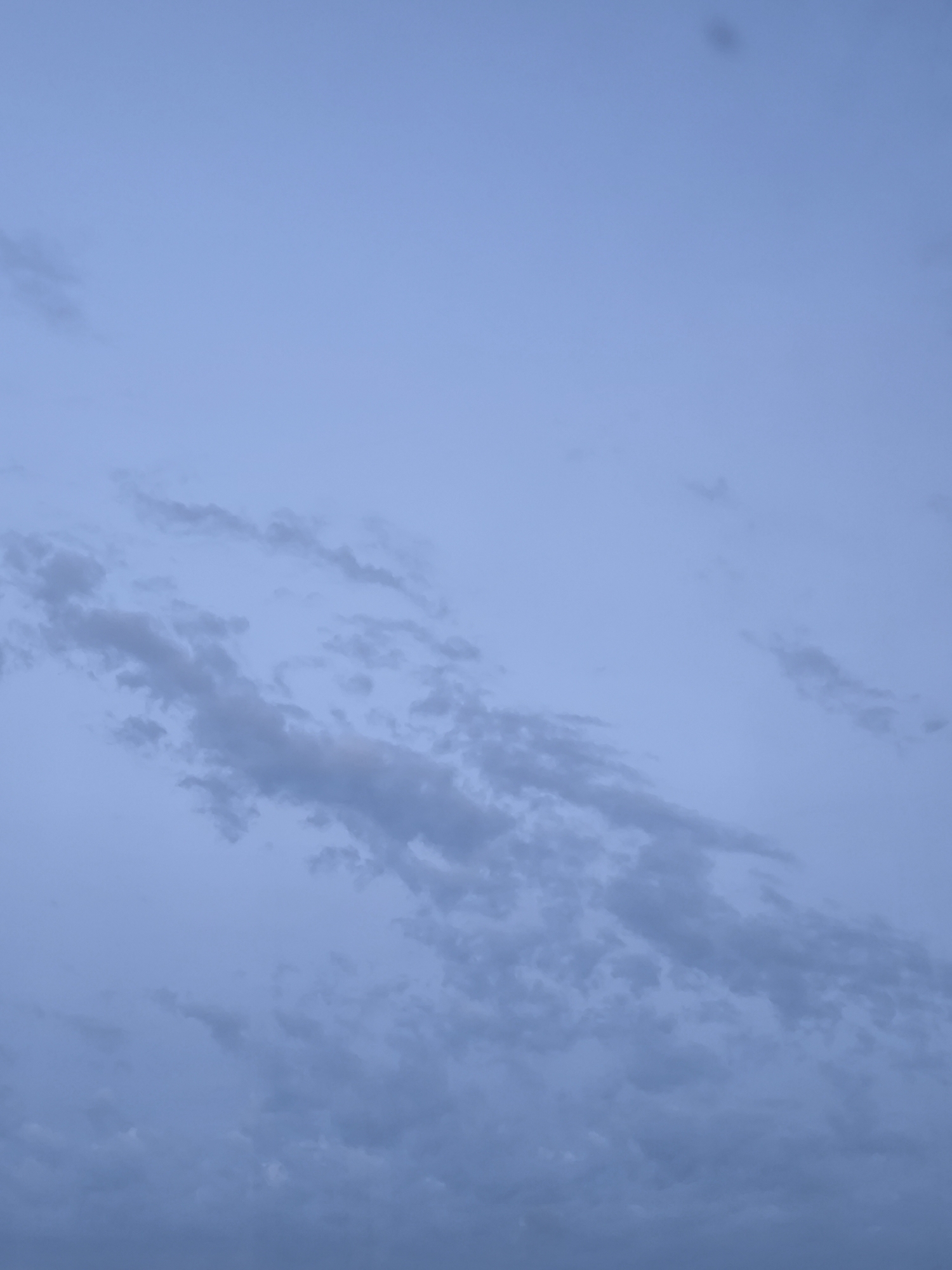 This media file depicts a clear sky with scattered clouds, likely taken in Apsheronsk, Russia. The lighting suggests it is either dawn or dusk, as the sky is a soft blue with a hint of purple. The clouds are wispy and thin, indicating fair weather. There are no people or objects visible in the frame, and no text is present. The scene is serene and peaceful, evoking a sense of calm and tranquility. The image focuses solely on the natural beauty of the sky, highlighting the subtle variations in color and cloud formations.
