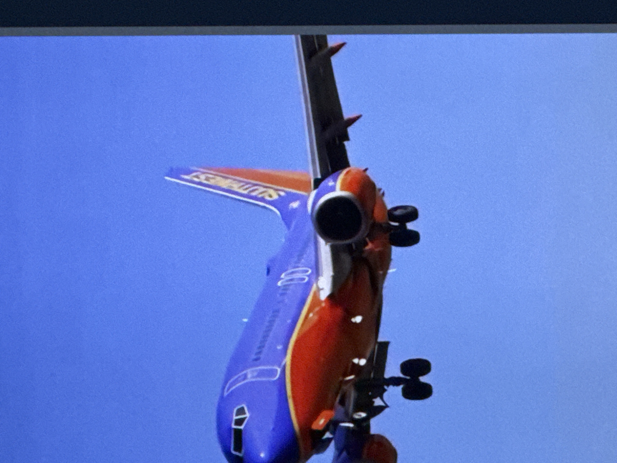 A low-angle shot captures a Southwest Airlines Boeing 737 aircraft in flight against a clear blue sky. The plane is painted in the airline's signature livery, with a purple fuselage and an orange and yellow stripe along its side. The landing gear is extended, suggesting the aircraft is either preparing to land or has just taken off. The image does not contain any information that would place it in the city of Cahul, Moldova, or any other specific geographic location.