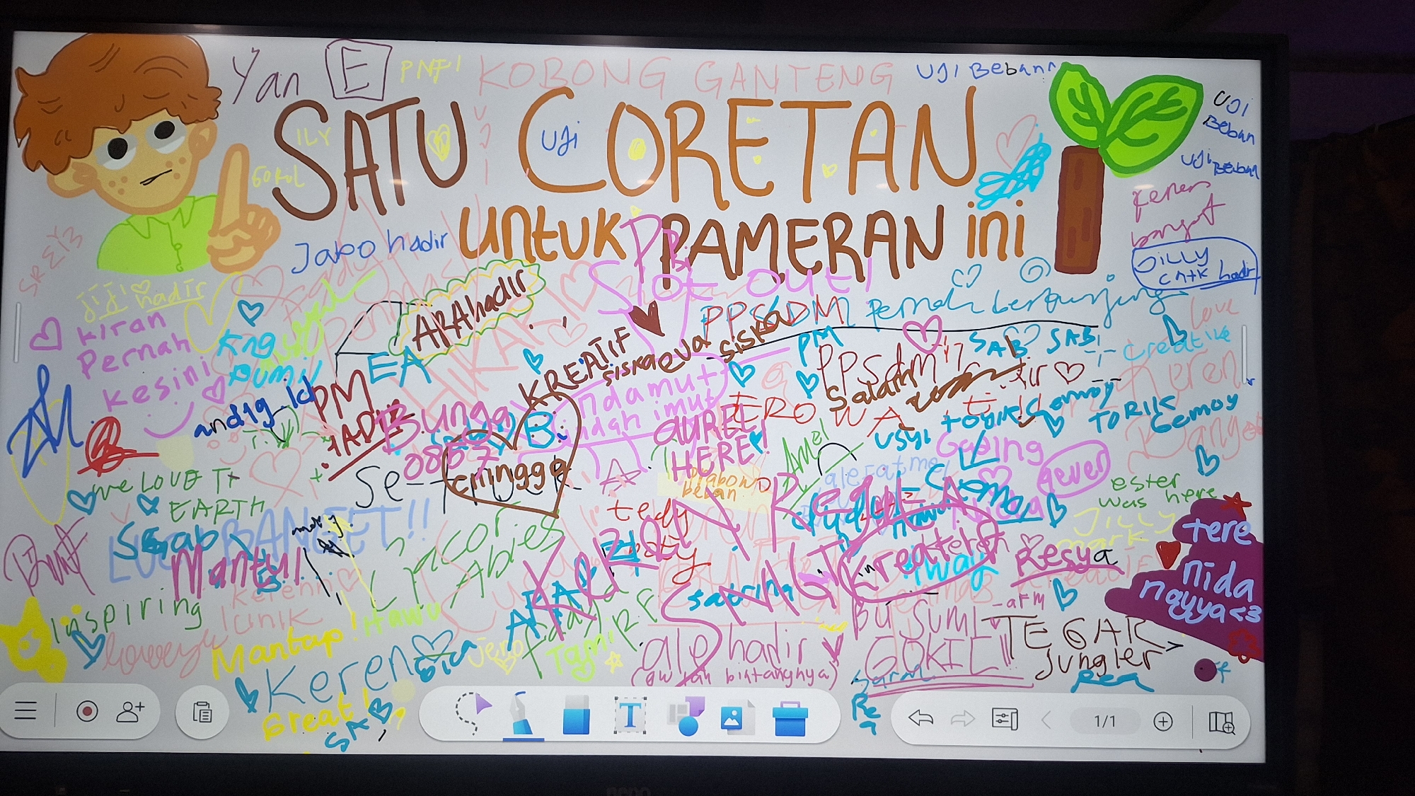 The image captures a brightly lit digital whiteboard, serving as an interactive guestbook or comment board at an exhibition in Sukaharja, Indonesia. The main title prominently displayed in brown letters reads, "SATU CORETAN UNTUK PAMERAN INI," which translates to "ONE DOODLE FOR THIS EXHIBITION," clearly outlining the purpose of the activity.
The screen is filled with a dense overlay of colorful digital handwriting, signatures, and small doodles, indicating numerous contributions from visitors. A cartoon character, a light-skinned boy with reddish-brown curly hair and freckles, wearing a green shirt, is drawn in the top left corner, pointing upwards. On the top right, a simple green plant drawing with a brown trunk is visible.
Among the many messages, names like "Jabo hadir" (Jabo is here), "Kiran Pernah kesini" (Kiran has been here), "ARAhadir," "Siskaeva," "AUREL," "Teddy," "ester was here," "tere," "Nida nayya <3," "Billy cntk hadir" (Billy pretty is here), "TORIS," "Gemoy," and "TEGAR Jungler" can be discerned. Positive comments and expressions of appreciation are abundant, including "KREATIF" (Creative), "Keren" (Cool), "Mantap" (Great), "GOKIL" (Crazy/Cool), "We LOVE T EARTH," "inspiring," and "unik" (unique). Some texts, like "UJI Beban" (Burden Test) appear multiple times. The diverse palette of colors used for the text and drawings, including brown, green, pink, blue, red, yellow, black, and purple, highlights the individual contributions and creative freedom.
At the bottom of the screen, a digital user interface with icons for menu, recording, users, clipboard, various pen tools, a text tool, shapes, images, a folder, and navigation controls, confirms that this is a digital interactive display. The scene conveys a sense of enthusiastic public participation and shared expression at an event.