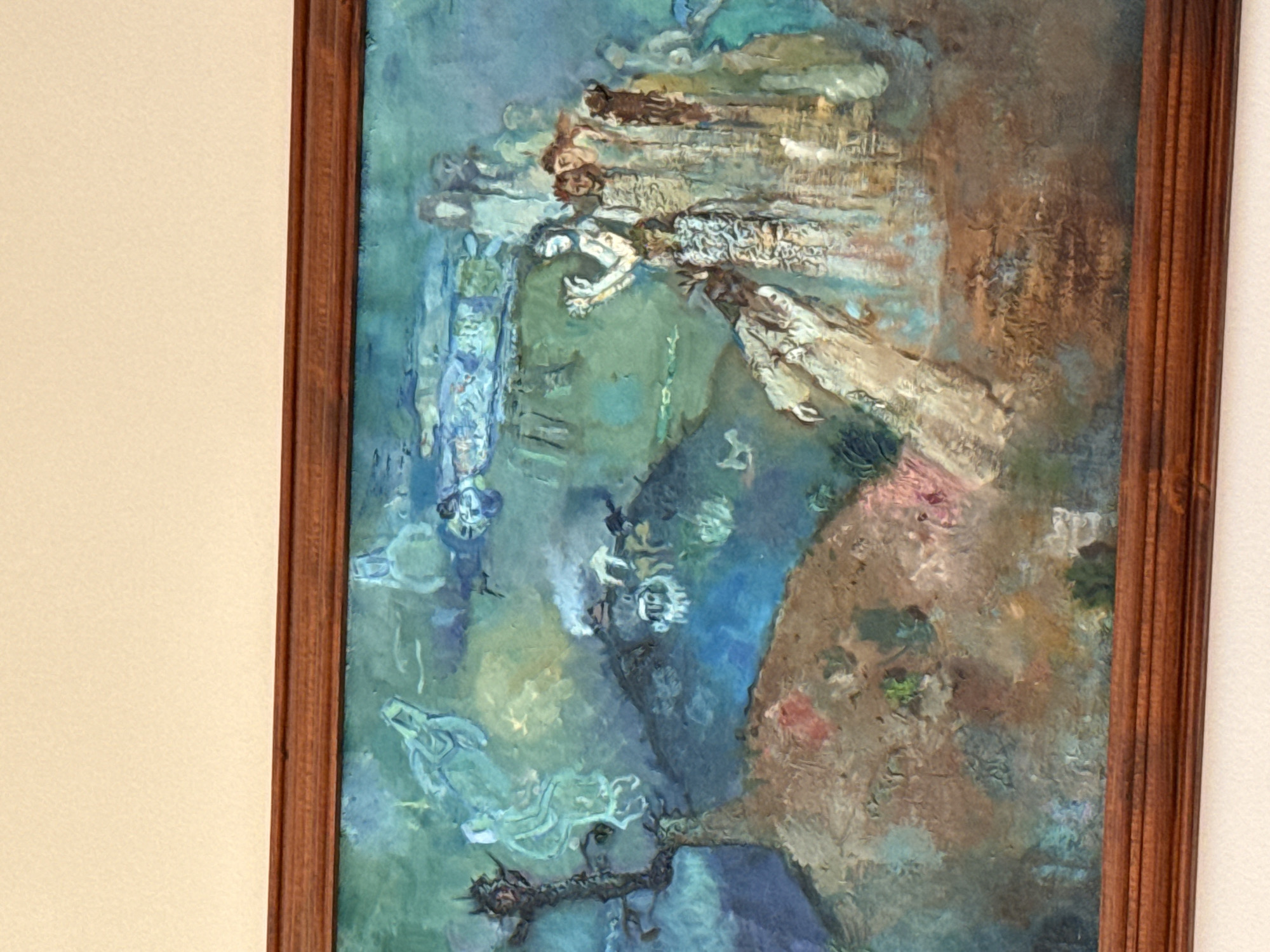 The image shows an oil painting in a wooden frame. The painting features abstract figures and forms in predominantly blue, green, and brown hues. The subject matter is unclear but appears to depict figures or shapes suggesting landscapes and characters with flowing robes. The style appears to be impressionistic or abstract.
There is no information to determine this image is of, or from Plovdiv, Bulgaria.