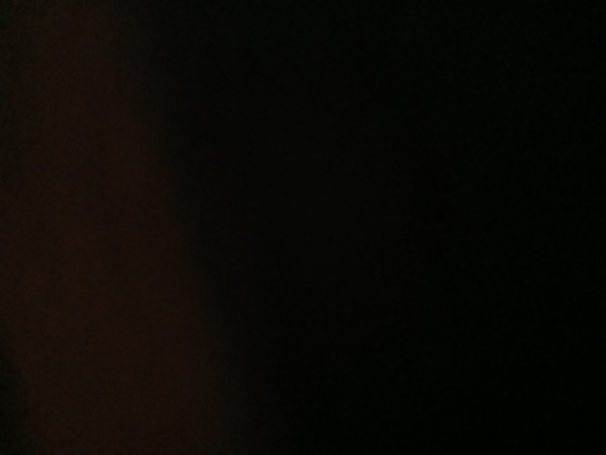 The image is extremely dark, with only a faint hint of a lighter area towards the top, possibly suggesting a ceiling or upper wall. The rest of the image is uniformly black, indicating a complete lack of visible detail or illumination. There are no discernable people, subjects, objects, actions, interactions, or environmental features present in the image due to the darkness. Therefore, it is impossible to ascertain any location, including Kademangan Kulon, Indonesia, or to provide a forensic, matter-of-fact description of a scene.