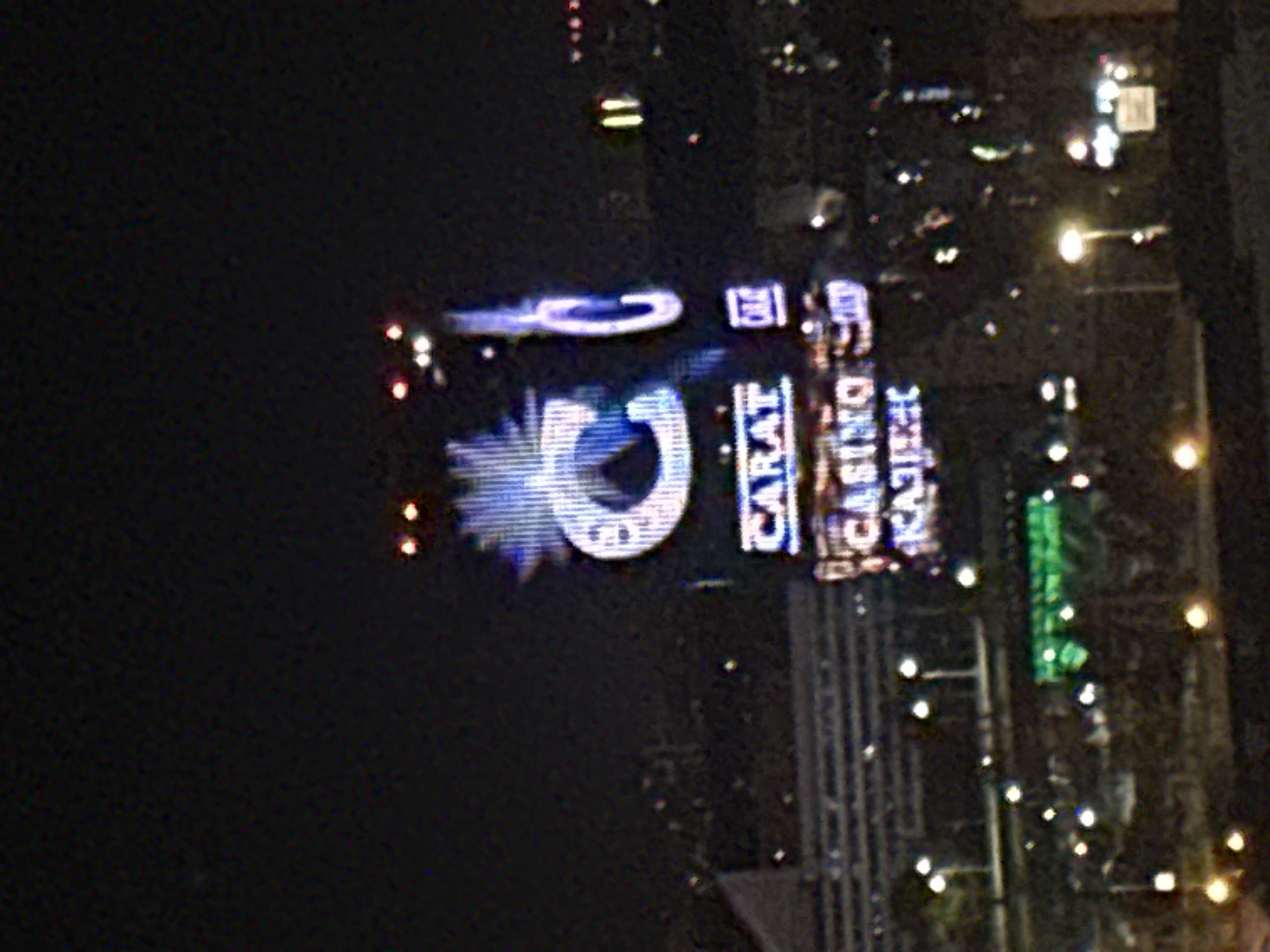 The image depicts a nighttime scene with illuminated signage for "CASINO KAJOT" and "CARAT." The buildings are lined with streetlights. The location is likely Бараўлянскі сельскі Савет, Belarus.