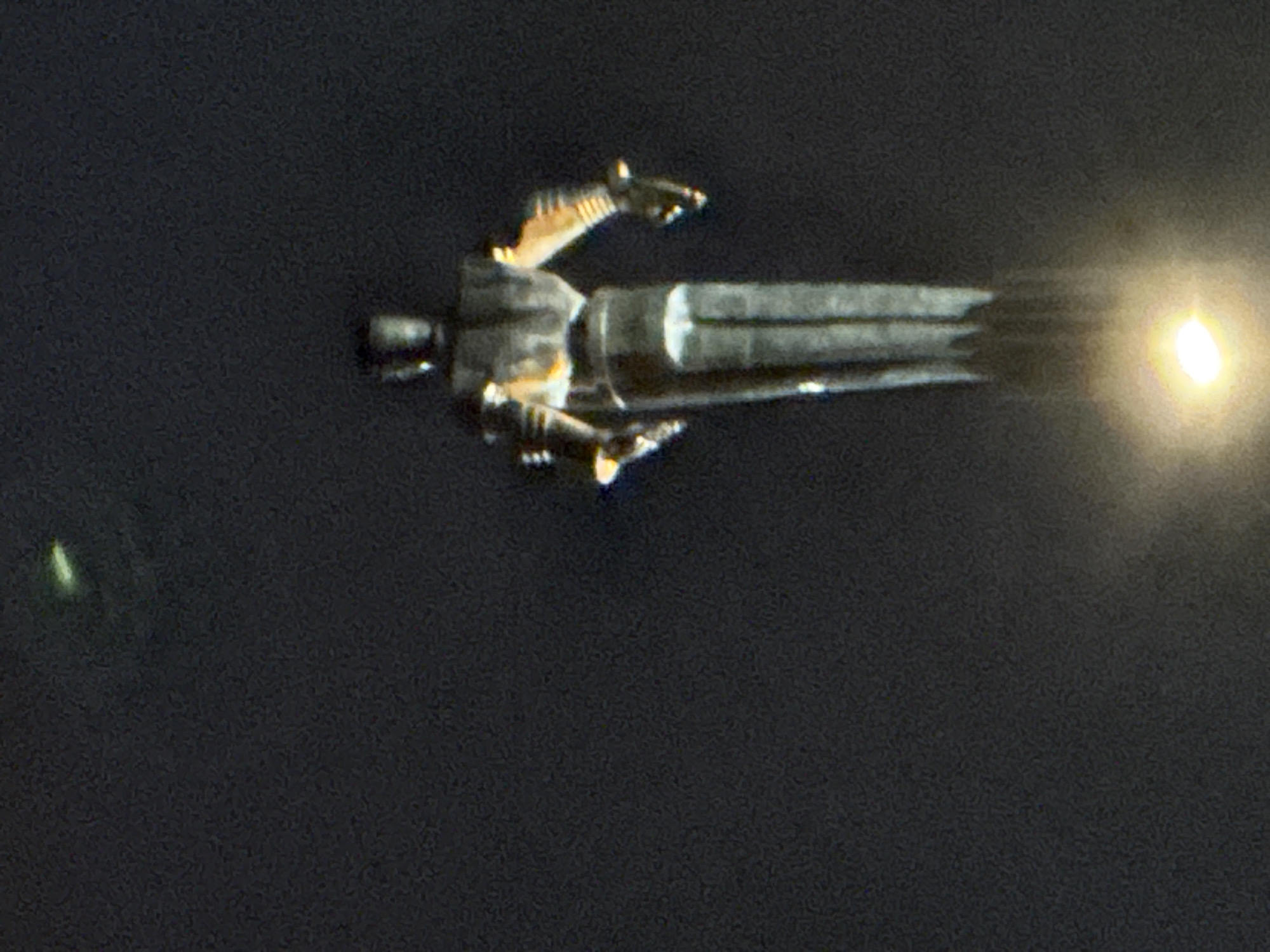 The image shows a model spaceship, possibly a toy, with bright light emanating from its rear, suggesting engine propulsion. It is set against a dark, blurred background that could be construed as night. There is no specific information in the image that directly links it to Moscow, Russia, or provides details about people or interactions.