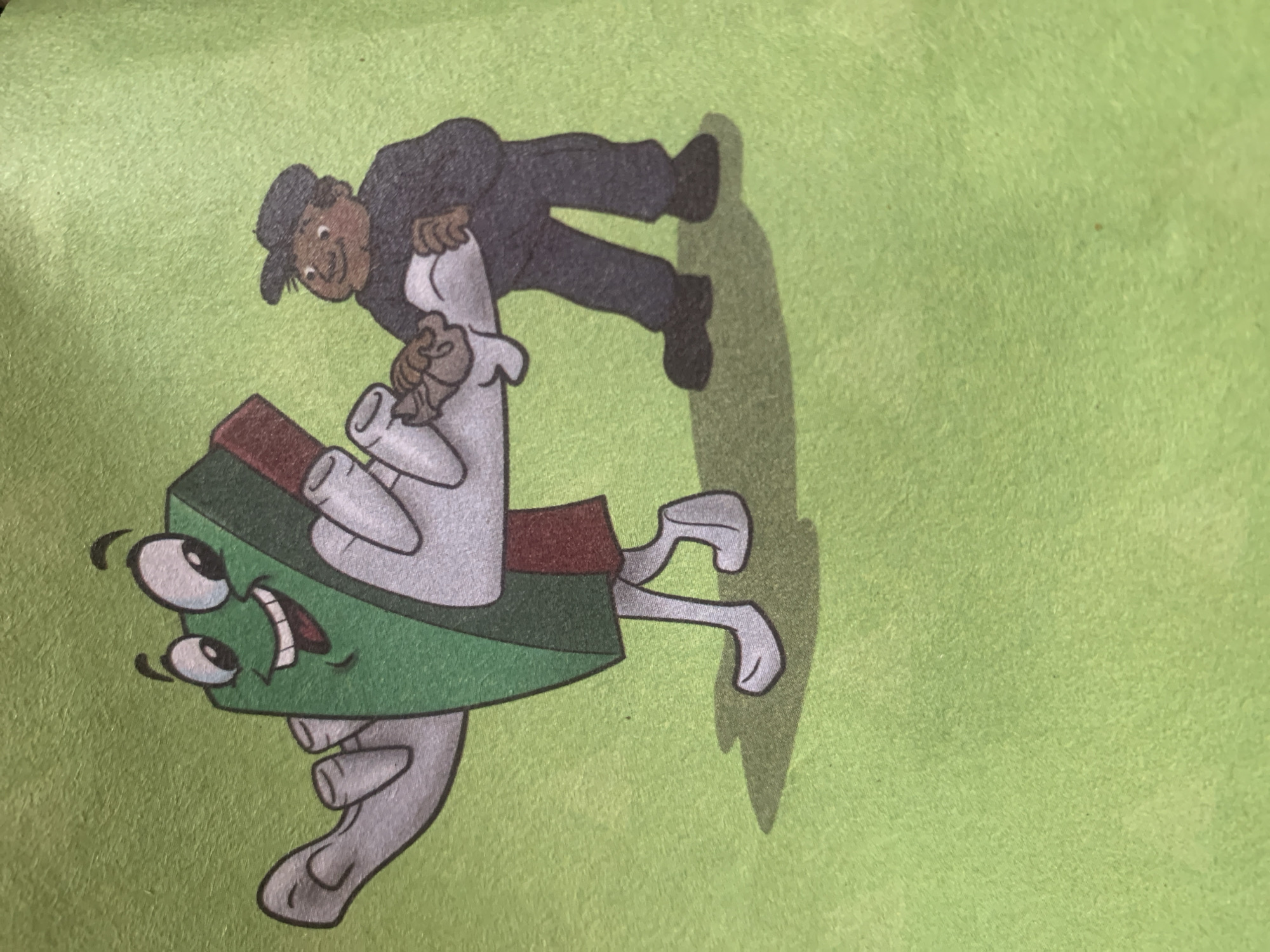 A cartoon illustration depicts a green and red rectangular object with arms, legs, and a face, smiling broadly with its mouth open. The object appears to be holding a white rolled-up material in its arms. To the right, a cartoon person with dark skin, wearing a dark hat and a dark jacket, is interacting with the rectangular object. The person is holding the white rolled-up material and appears to be either handing it to or receiving it from the object. Both figures have a playful and friendly demeanor. The background is a solid, textured light green. The image is presented on a flat surface with a subtle shadow cast beneath the figures. The specific location of Jauro Yinu, Nigeria, is not depicted or suggested by any elements within the image itself.
