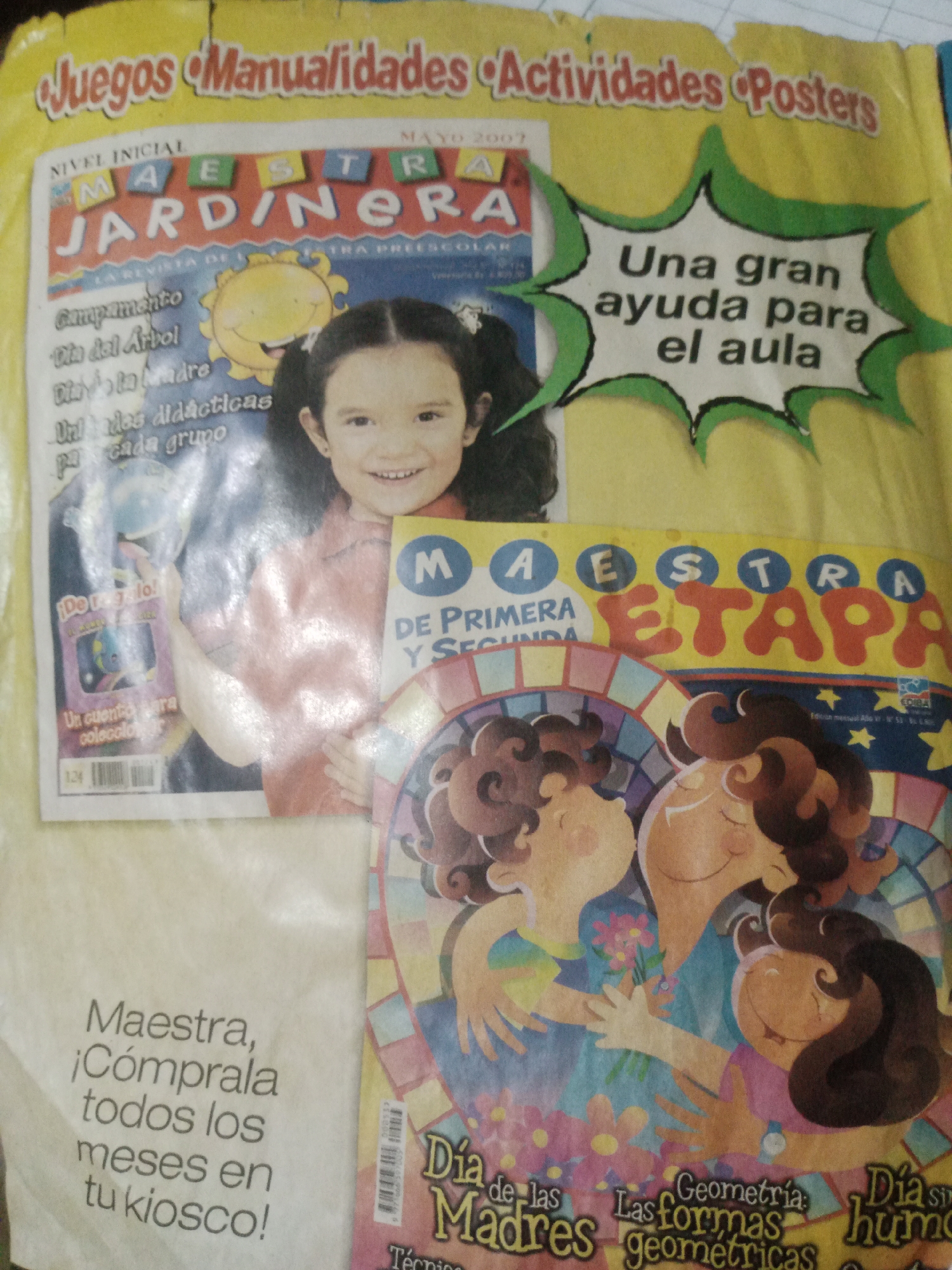 The image shows the cover of a magazine titled "Maestra Jardinera" and another magazine titled "Maestra Etapa" overlapping it. The "Maestra Jardinera" magazine features a young girl smiling broadly at the viewer. Text on this magazine includes "NIVEL INICIAL," "MAYO 2007," "Campamento," "Día del Árbol," "Día de la Madre," and "Utilidades didácticas para cada grupo." To the right of the girl, a speech bubble with a green border contains the text "Una gran ayuda para el aula." The "Maestra Etapa" magazine has a colorful illustration of three figures embracing, likely a mother and two children, with flowers. Text on this magazine includes "Día de las Madres" and "Geometría: Las formas geométricas." The background is a yellowish, crinkled paper material, suggesting it might be a printed page or a poster that has been folded or creased. The scene is a close-up of these magazines and does not provide any information about the city of Santa Ana, Venezuela.
